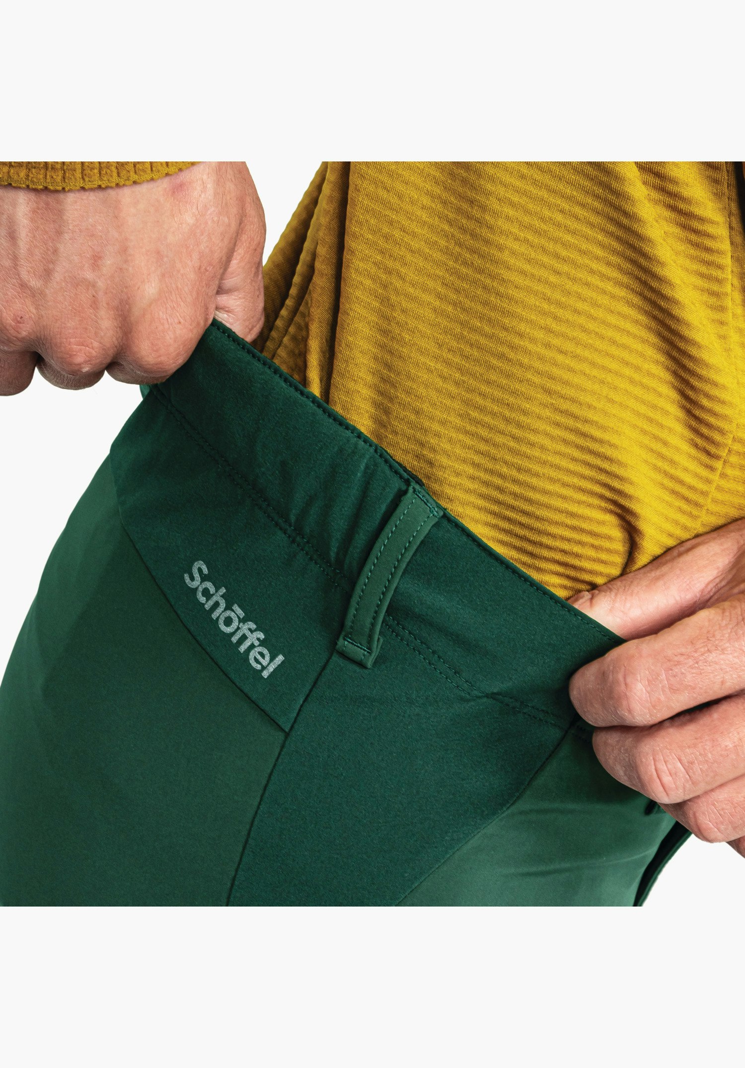 Softshell Pt Style Milagle MNS. Vue détaillée de la ceinture verte avec passants et l'inscription Schöffel sur la hanche. Gros plan sur fond blanc/neutre.