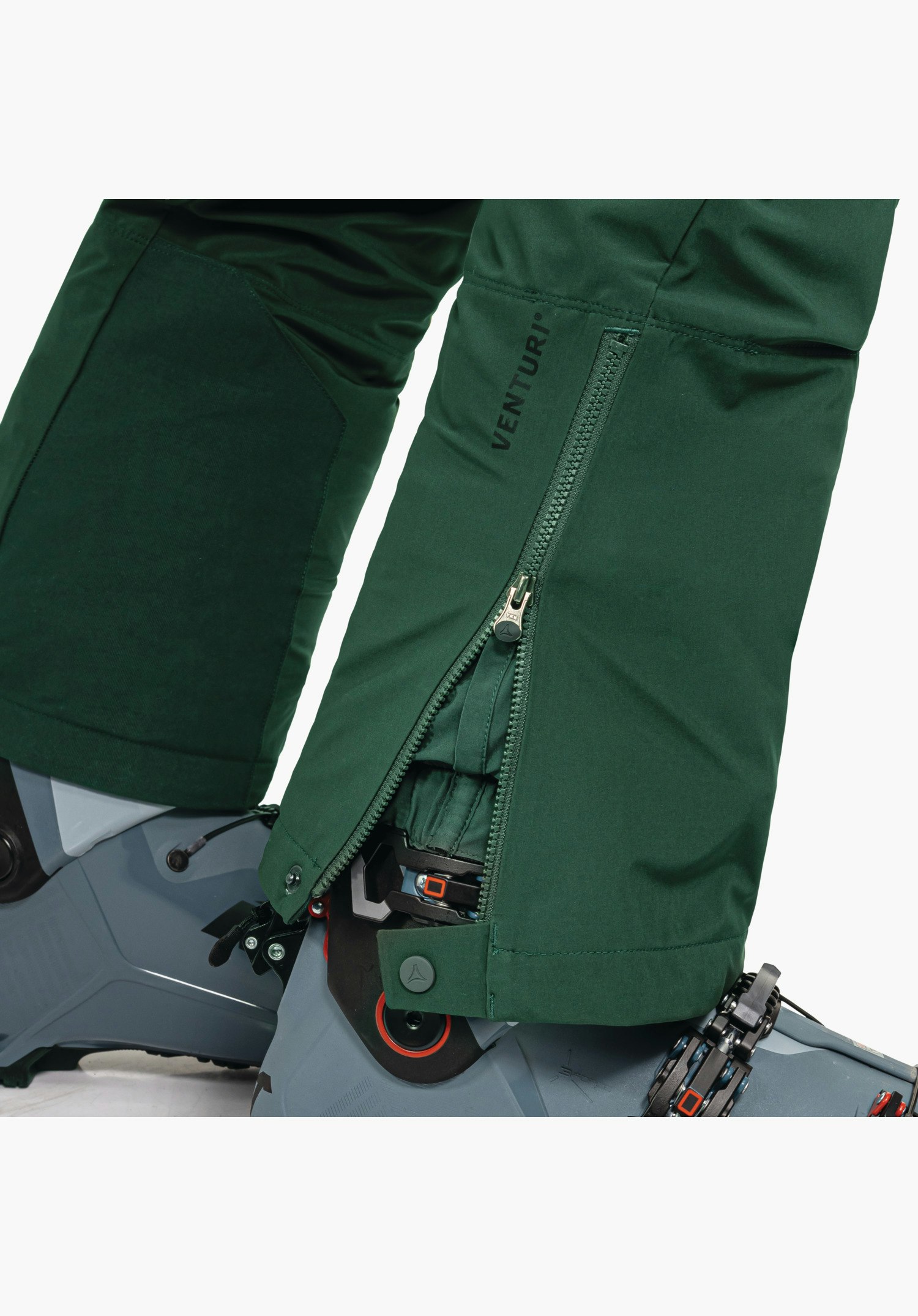 Softshell Pt Style Milagle MNS présentant la zone de l'épaule avec le logo Schöffel brodé sur la manche et l'emblème sur la poitrine sur un tissu vert, gros plan sur fond blanc.