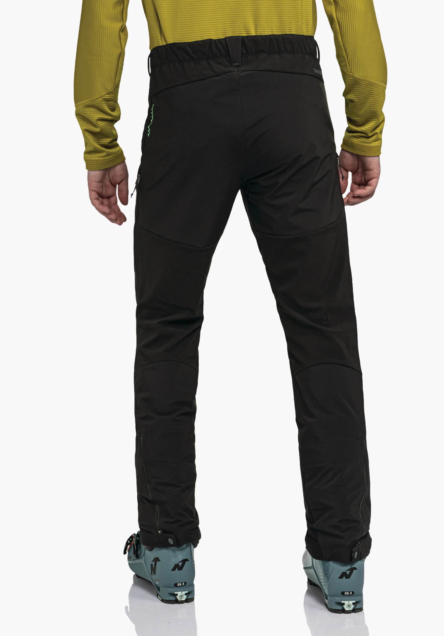 Softshell Pt Style Milagle MNS black trousers worn standing upright; dark yellow top and light blue ski boots visible; studio shot against a white background.