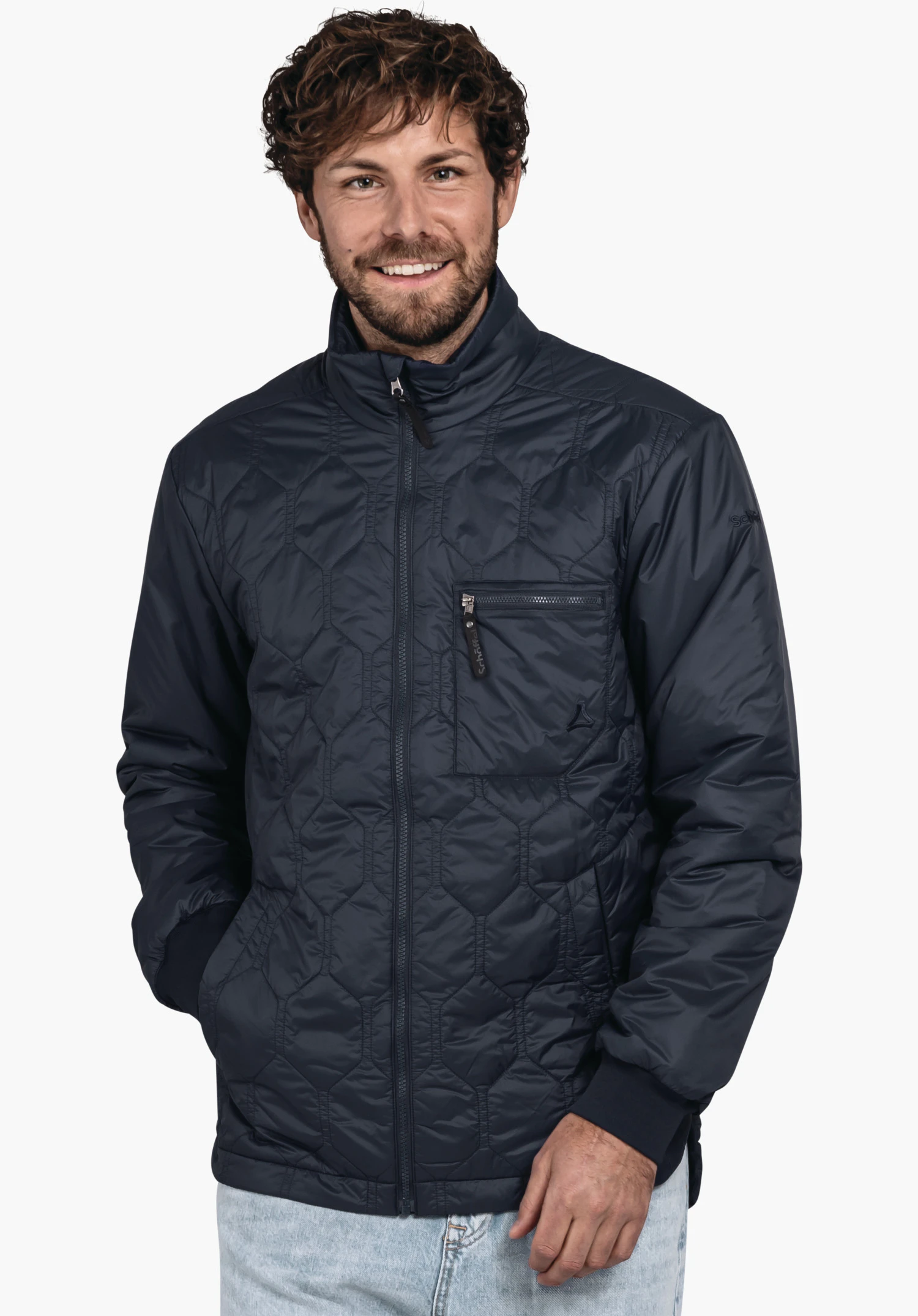 Ins Jacket Style Malkay MNS man wearing a dark blue quilted jacket, standing smiling with hands in pockets against a light background. Schöffel logo visible. Text: “Schöffel”.