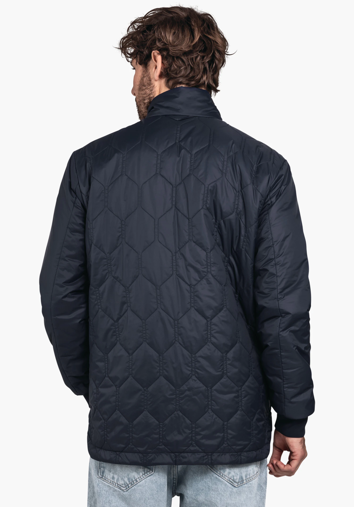 Ins Jacket Style Malkay MNS dark blue hexagon-quilted jacket worn from the back; light neutral background, light blue jeans visible.