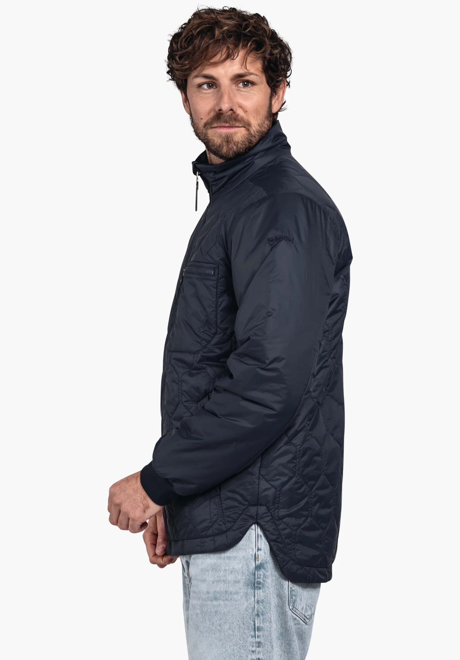 Ins Jacket Style Malkay MNS dark blue quilted jacket worn by a bearded man looking side-on; wears light blue jeans in front of a white studio background. Lettering: "Schöffel".