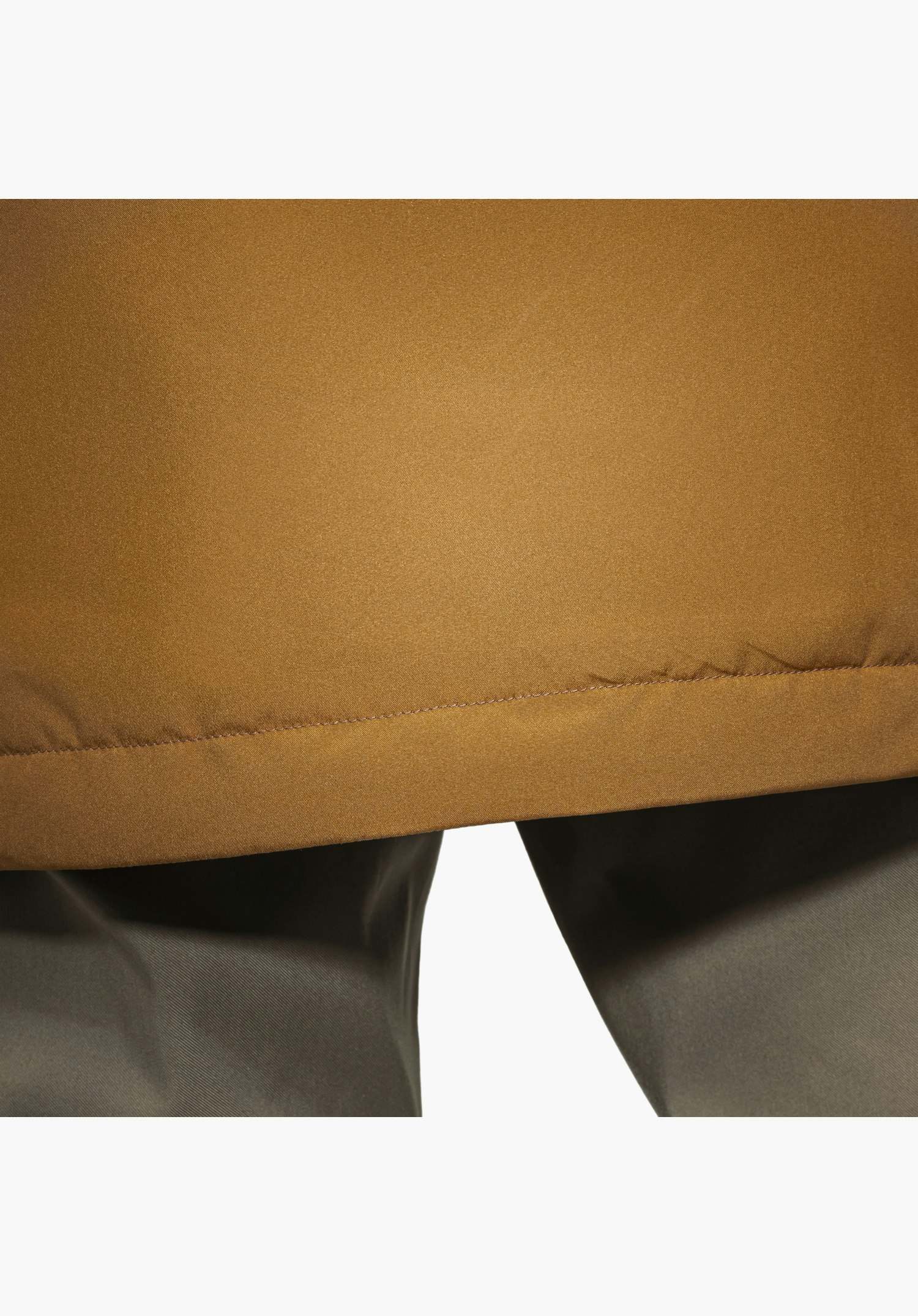 Ins Parka Style Malkay MNS zeigt ein reflektierendes Detail auf dem braunen Material im unteren Bereich, Nahaufnahme vor weißem/neutralem Hintergrund.