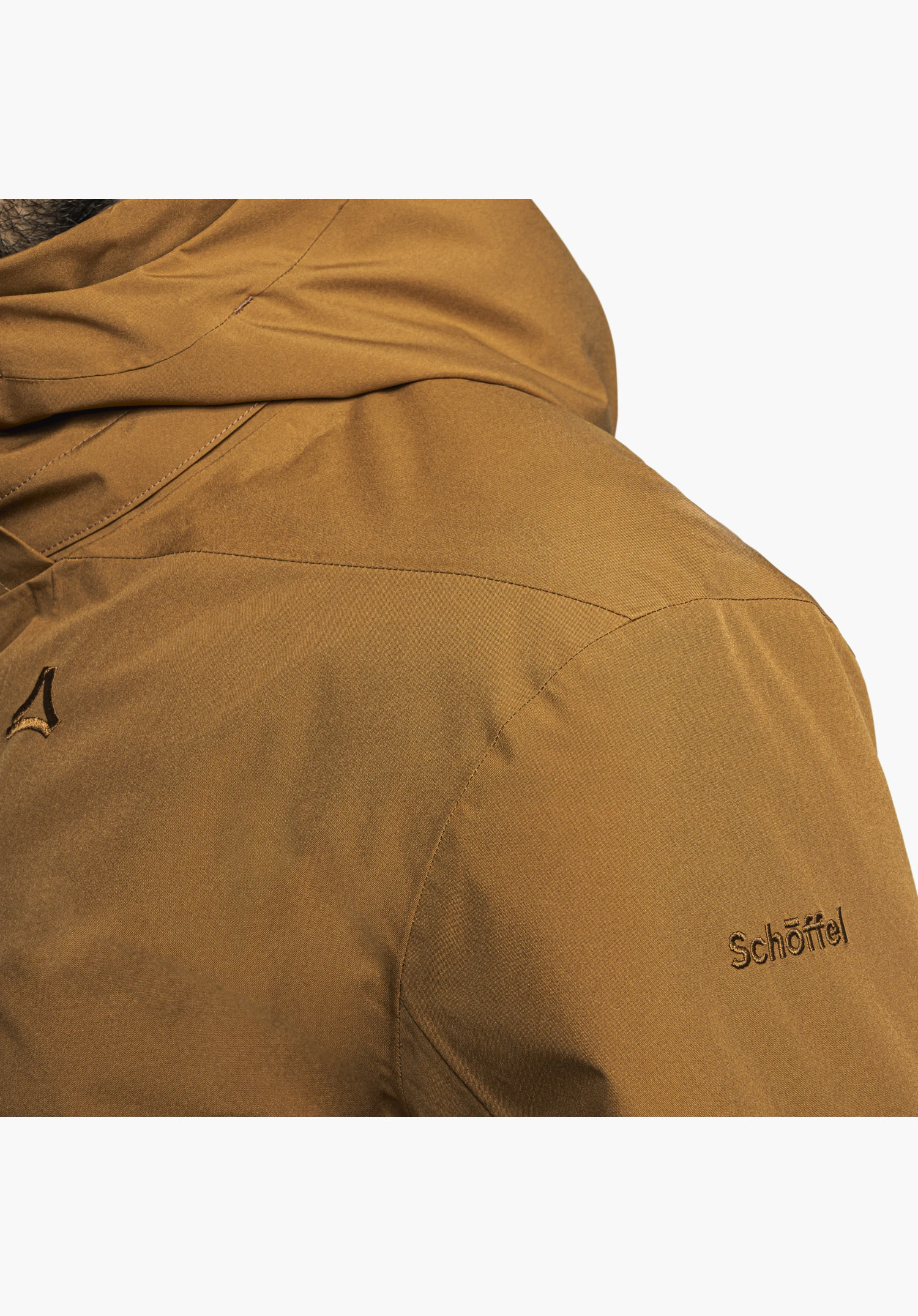 Ins Parka Style Malkay MNS zeigt ein Detail des Ärmels in Braun mit einer kleinen Reißverschlusstasche, aus der ein weißes Label mit dem Schriftzug „Ich bin raus.“ hervorsteht, Nahaufnahme vor weißem Hintergrund.