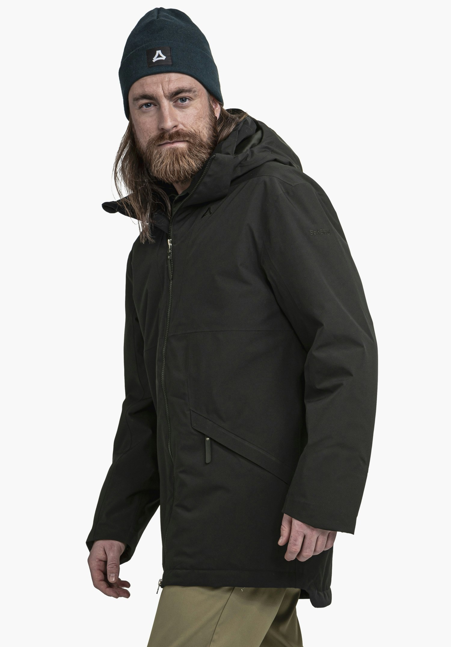 Ins Parka Style Malkay MNS dunkelgrüne Jacke, getragen von barttragendem Mann, der leicht zur Kamera blickt; er trägt ein dunkelblaues Beanie mit Schöffel-Logo; weißer Hintergrund. Text: "Schöffel".