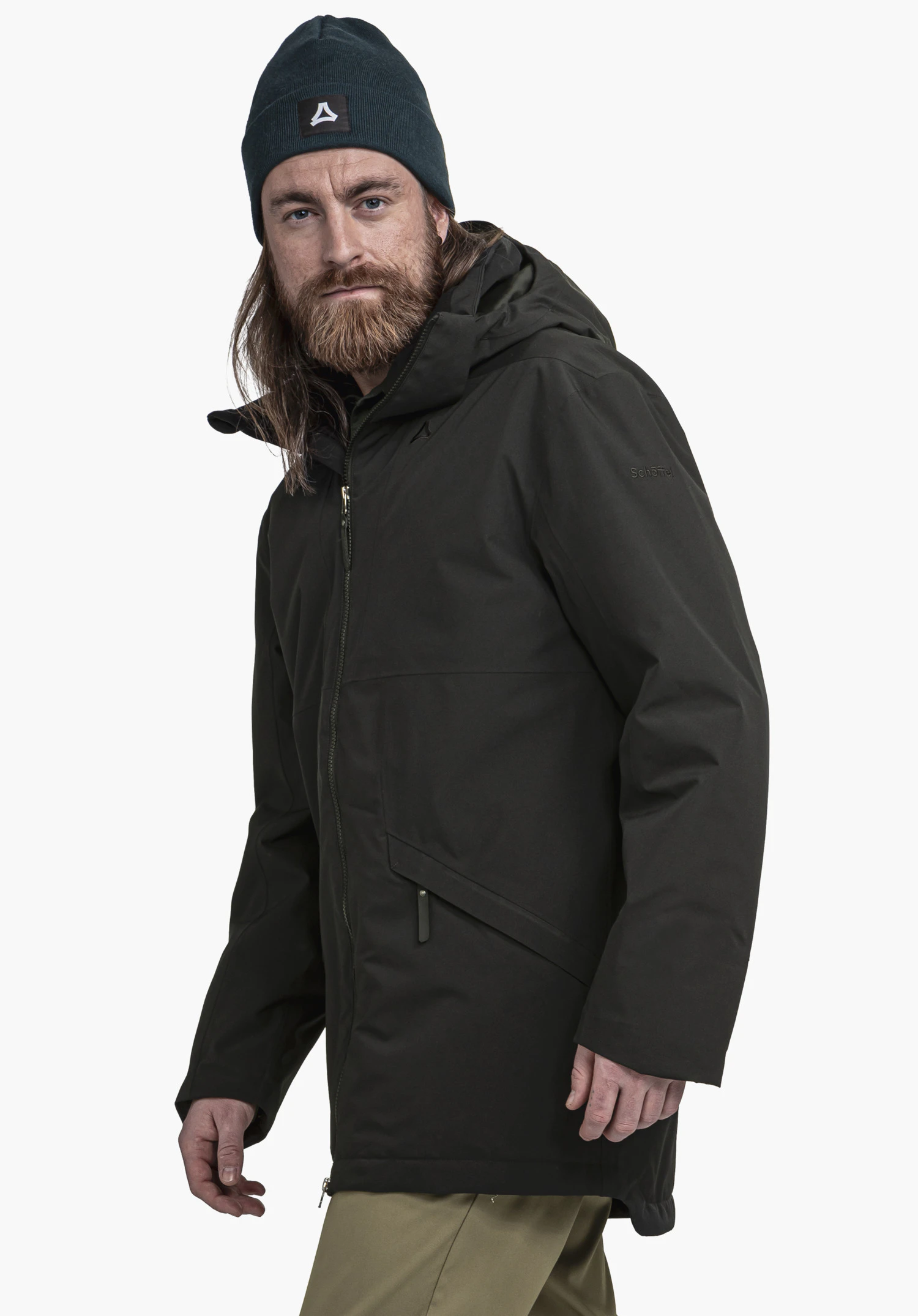 Ins Parka Style Malkay MNS dark green jacket worn by a bearded man looking slightly towards the camera; wears a dark blue beanie with Schöffel logo; white background. Text: "Schöffel".