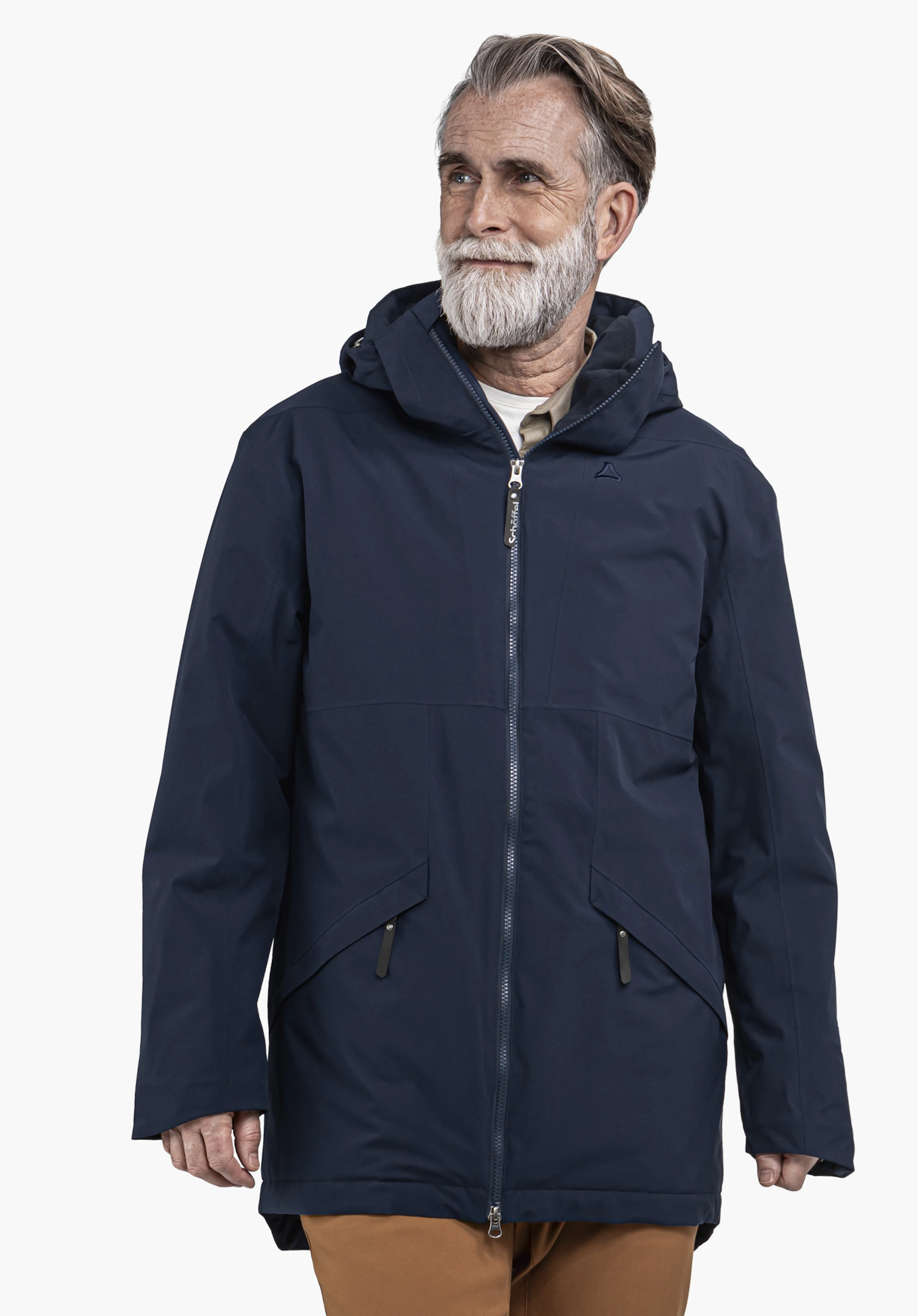 Ins Parka Style Malkay MNS Parka bleu foncé à capuche porté par un homme; logo Schöffel sur la poitrine; texte «Schöffel» sur le tire-zip; fond clair, debout regardant vers la droite.