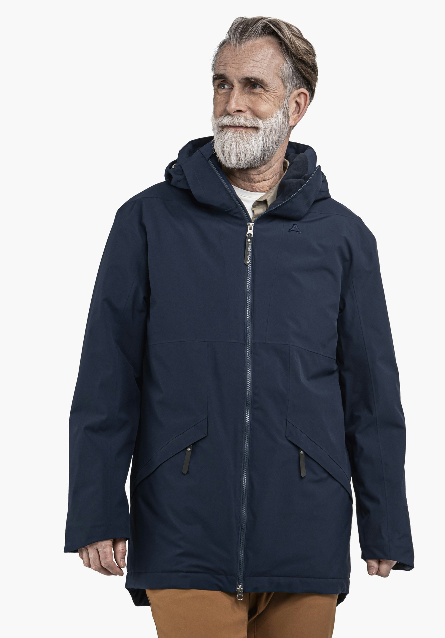 Ins Parka Style Malkay MNS dunkelblauer Parka mit Kapuze, getragen von einem Mann; Schöffel-Logo auf der Brust; Reißverschluss mit Text "Schöffel"; heller Hintergrund, stehend, blickt nach rechts.