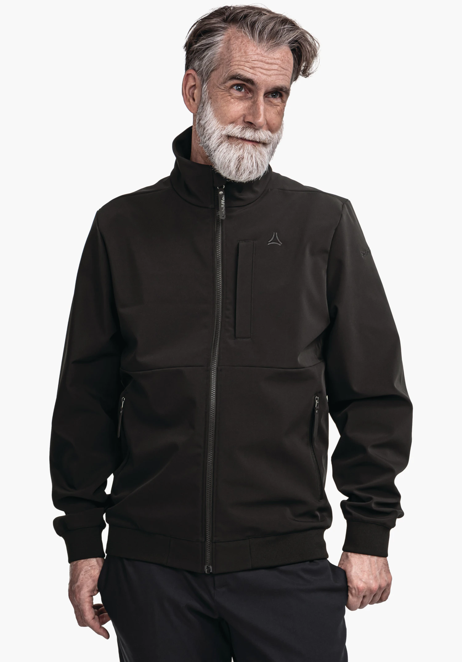 Softshell Jk Style Suavio MNS Homme portant une veste noire profonde avec zip intégral et logo Schöffel sur la poitrine; debout légèrement de biais, mains détendues le long du corps, fond clair.