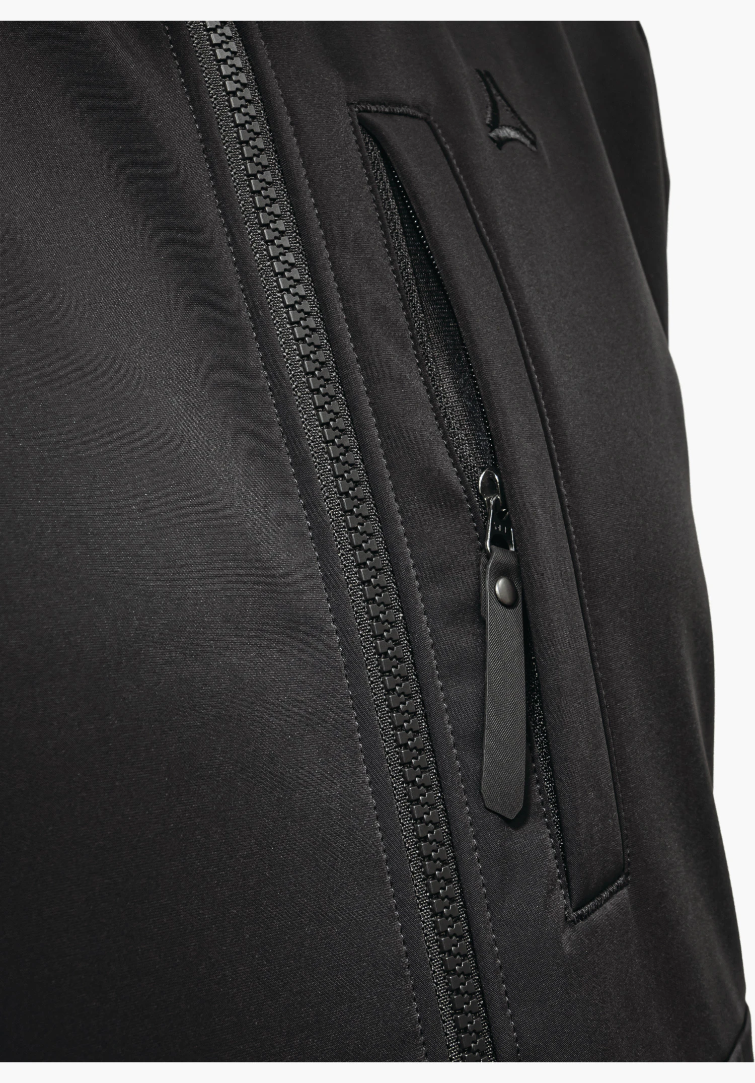 Softshell Jk Style Suavio MNS montre la partie poitrine avec la fermeture éclair frontale, la poche poitrine verticale avec une tirette marquante en noir et le logo Schöffel en gros plan sur fond blanc.