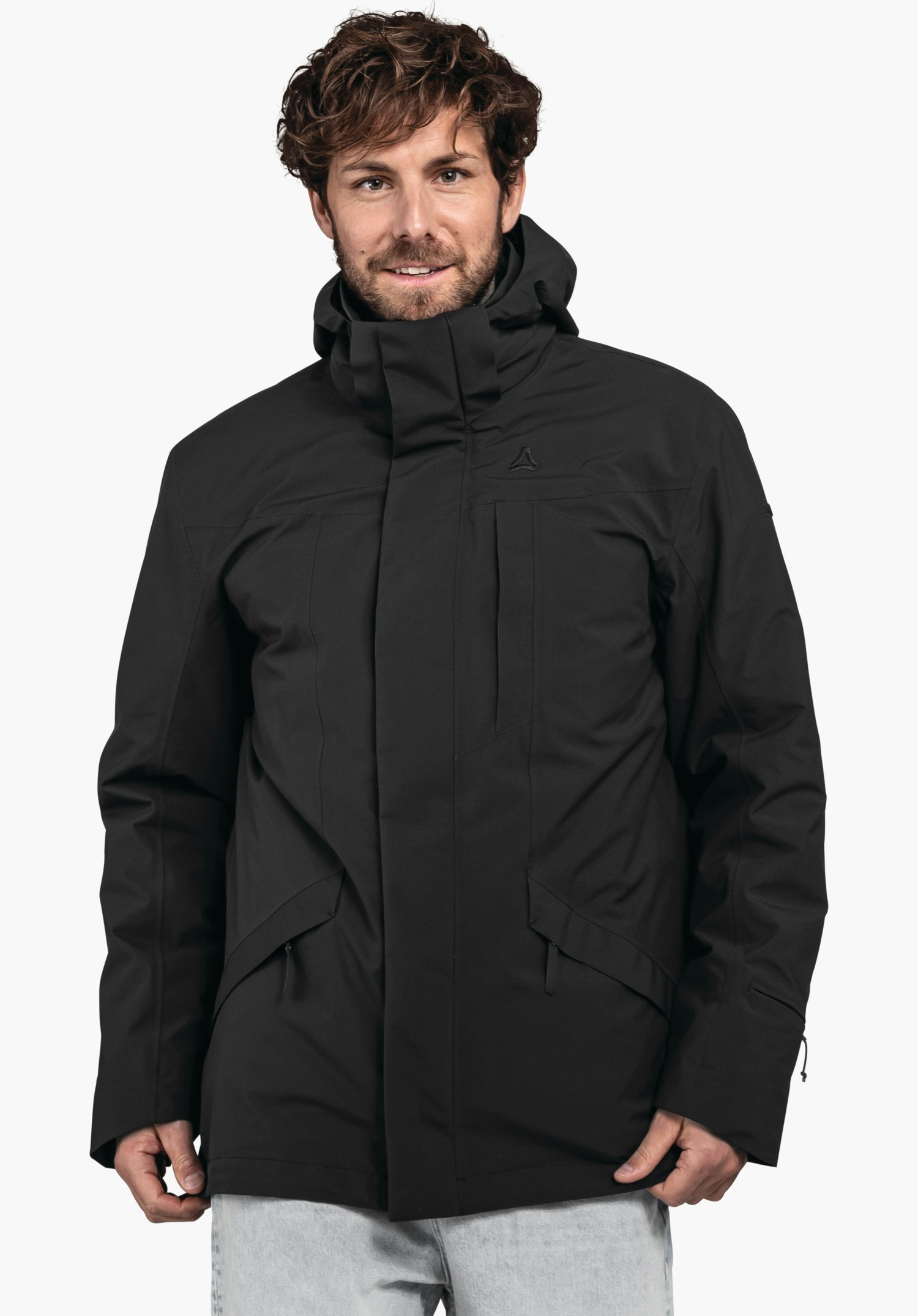 3in1 Parka Style Borkol MNS schwarze Jacke; Mann trägt sie mit hochgestellter Kapuze, linke Hand in Tasche, rechte Hand entspannt; Schöffel-Logo auf der Brust; neutrale Studio-Umgebung.