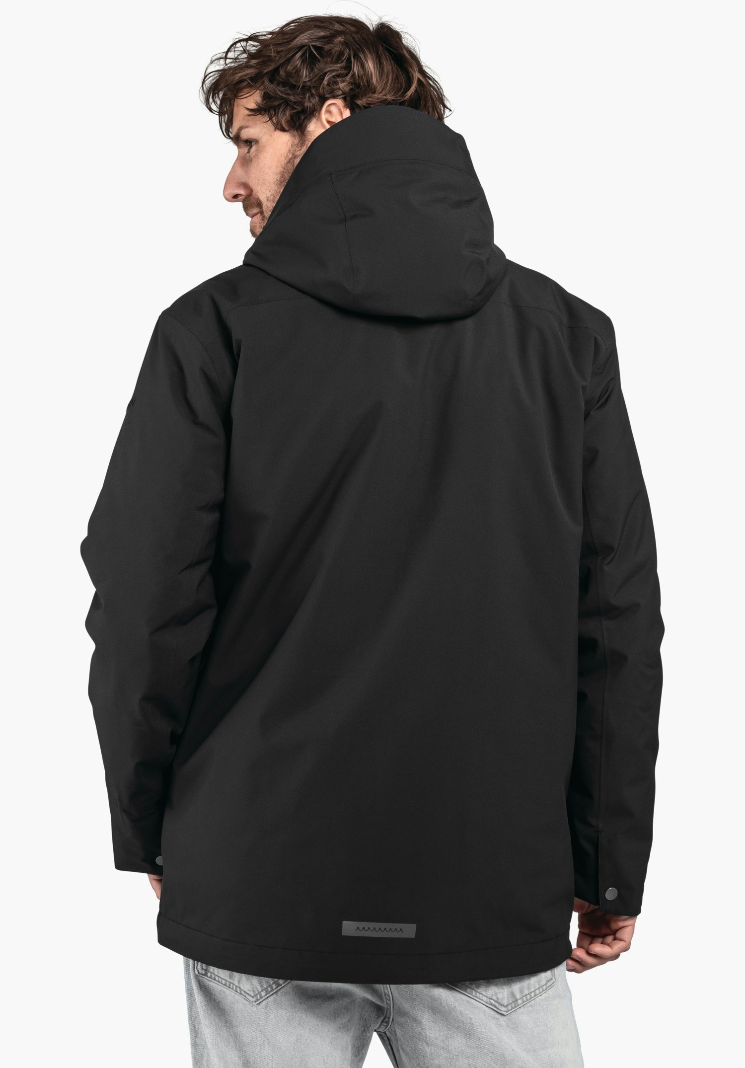 3in1 Parka Style Borkol MNS dunkelschwarze Kapuzenjacke, von einem Mann getragen, steht mit dem Rücken zur Kamera; Mann schaut nach rechts; Hintergrund weiß.