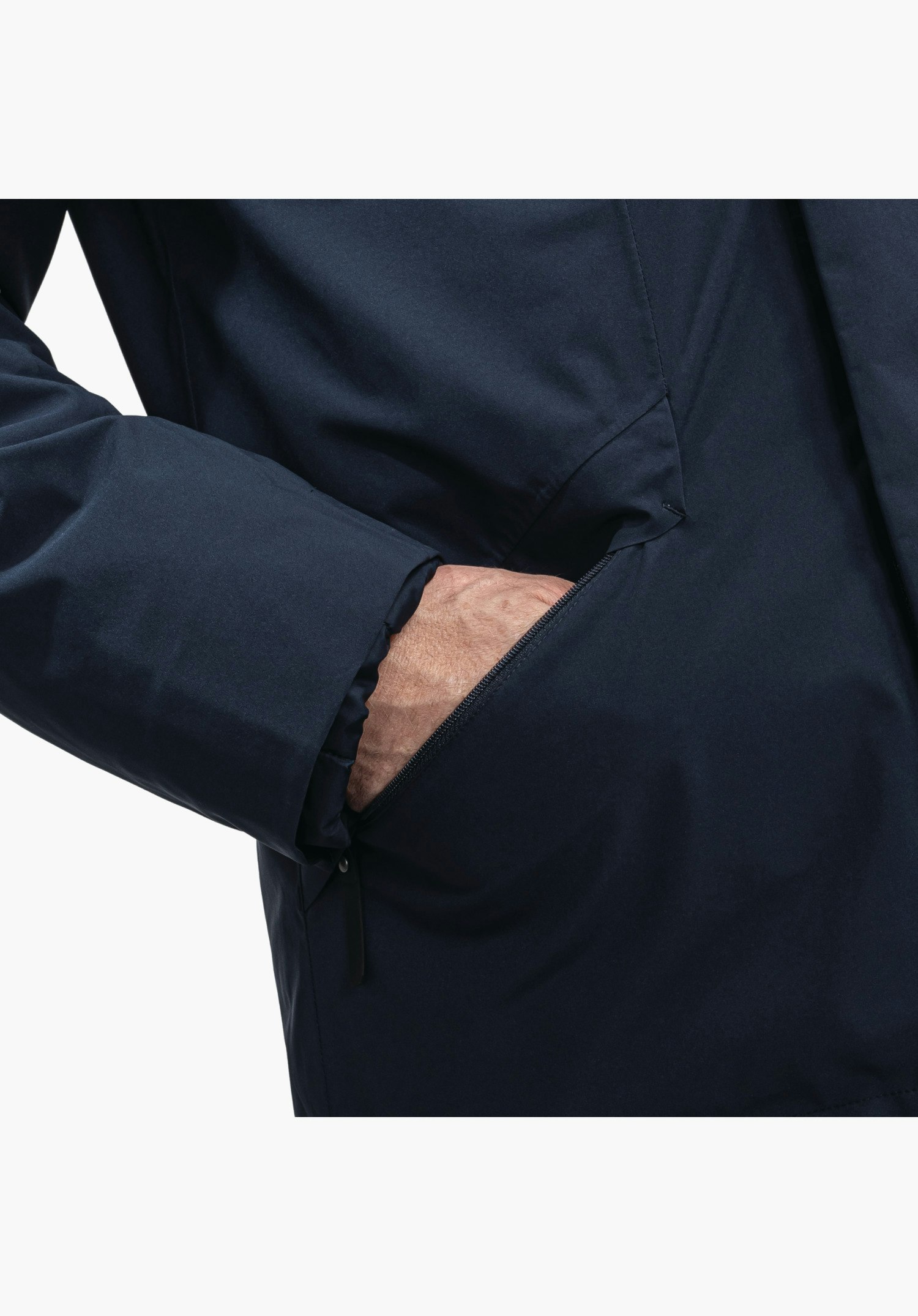 3in1 Parka Style Borkol MNS, toont de zijzak met rits in de blauwe stof terwijl een hand erin grijpt, close-up tegen een witte achtergrond.