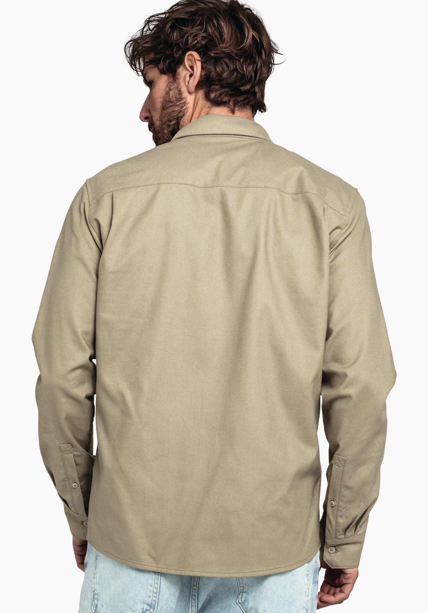 Shirt Style Kleion MNS Rückenansicht eines hellgrünen Langarmhemds, locker getragen von stehender Person; Hemd mit Kragen und Manschetten, über hellblauen Jeans vor weißem Hintergrund.