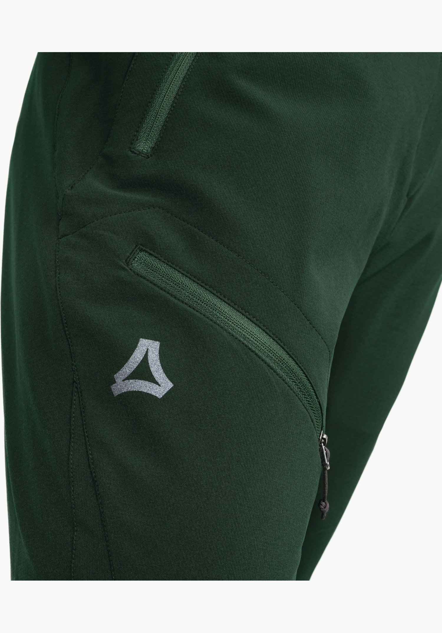 Pants Style Cascata WMS toont een ritszak op het groene bovenbeen en het zilveren Schöffel-logo in een close-up tegen een witte achtergrond.