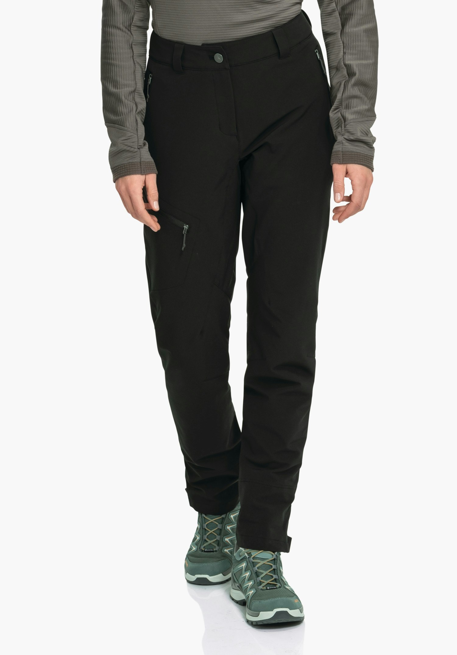 Pants Style Cascata WMS Pantalon de randonnée noir porté par une personne avançant légèrement; poche zippée visible sur la cuisse droite, mains détendues le long du corps; contexte: fond clair neutre, chaussures de randonnée vert foncé.