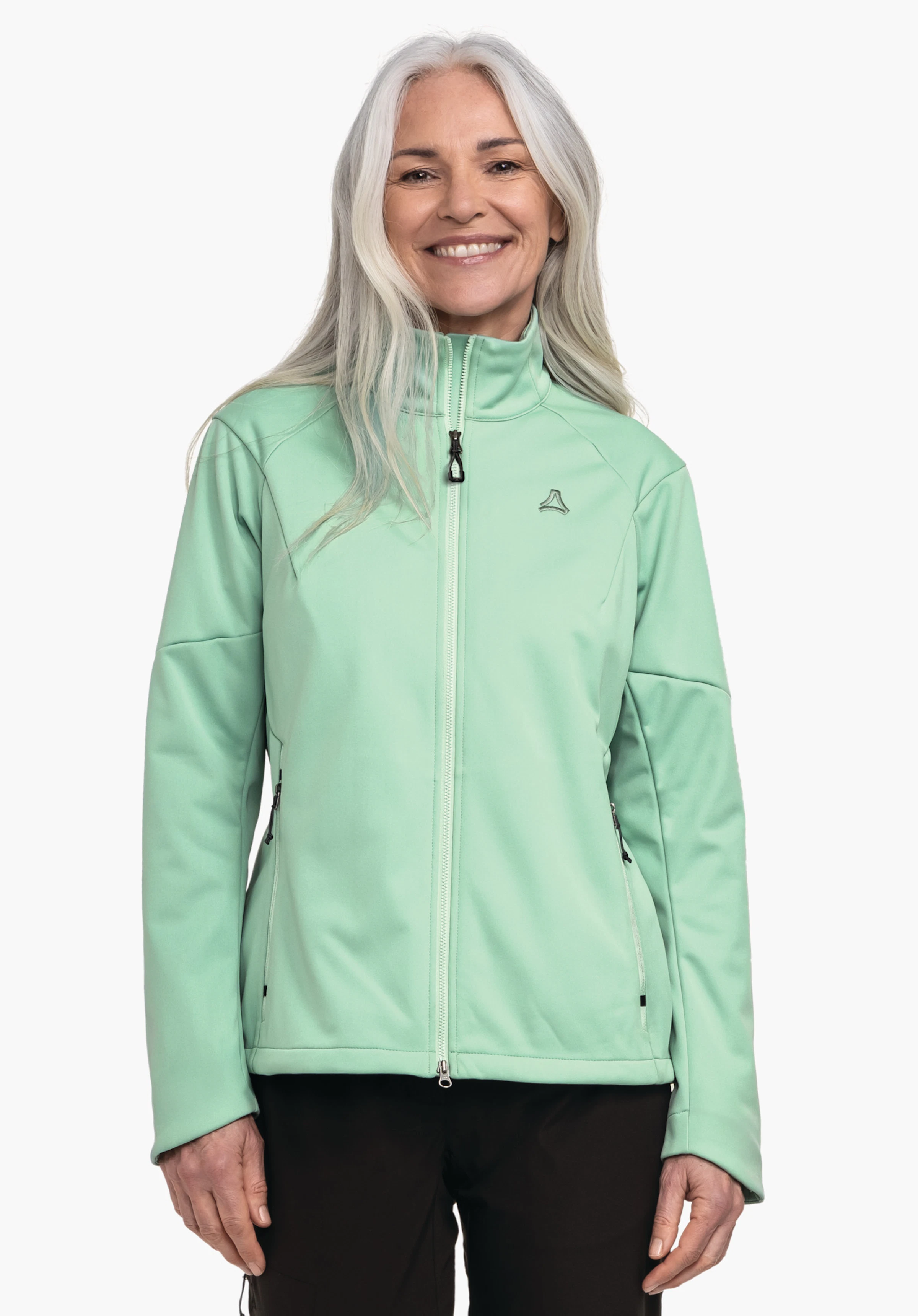 Softshell Jk Style Fracon WMS Hellgrüne Jacke, getragen von lächelnder Person, stehend vor weißem Hintergrund; Schöffel-Logo auf linker Brust, schwarze Hosen sichtbar.