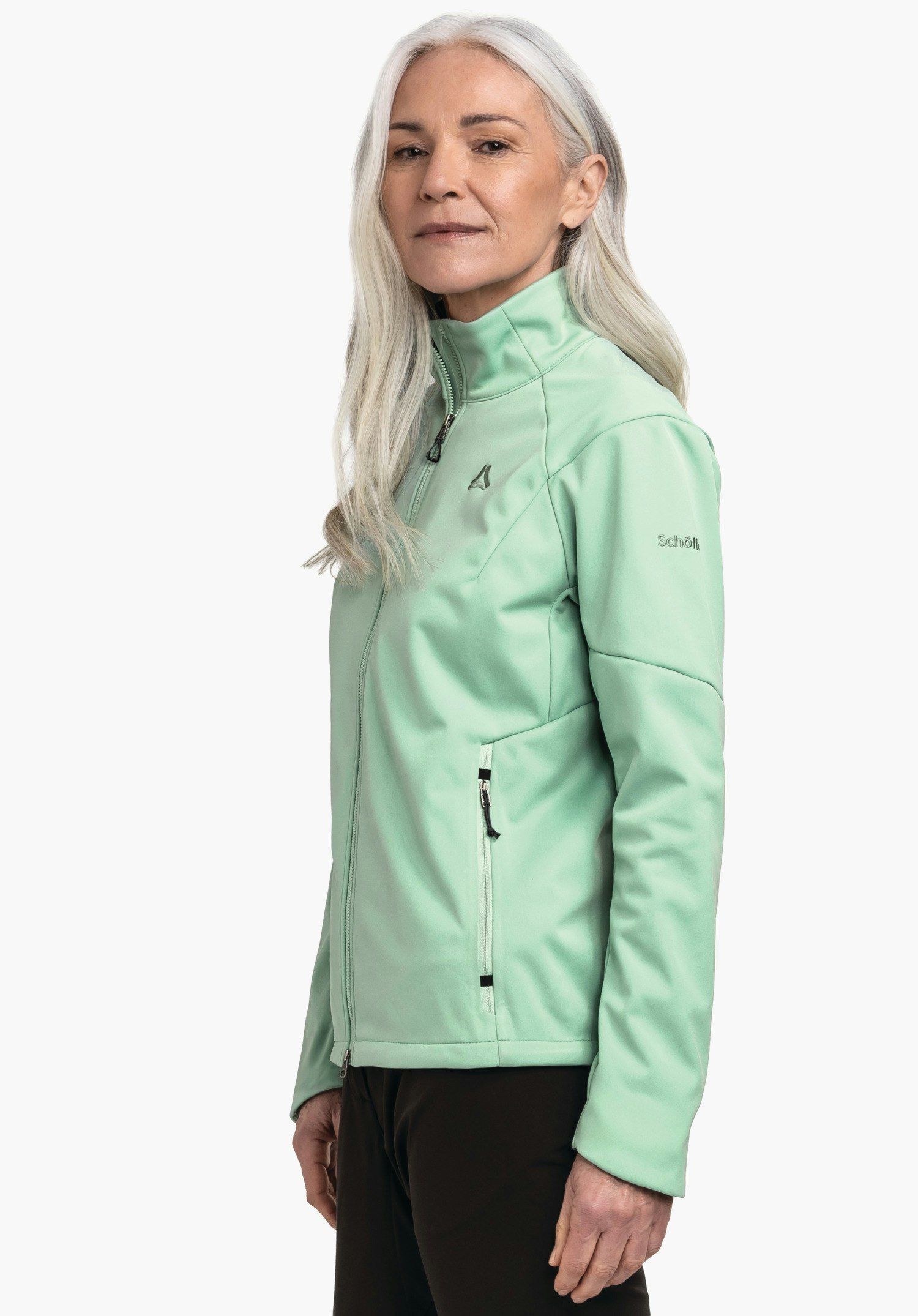 Softshell Jk Style Fracon WMS hellgrüne Softshelljacke, getragen von einer älteren Frau im Seitenporträt; Schöffel-Logo auf der Brust, Schriftzug "Schöffel" auf dem Ärmel; weißer Hintergrund.