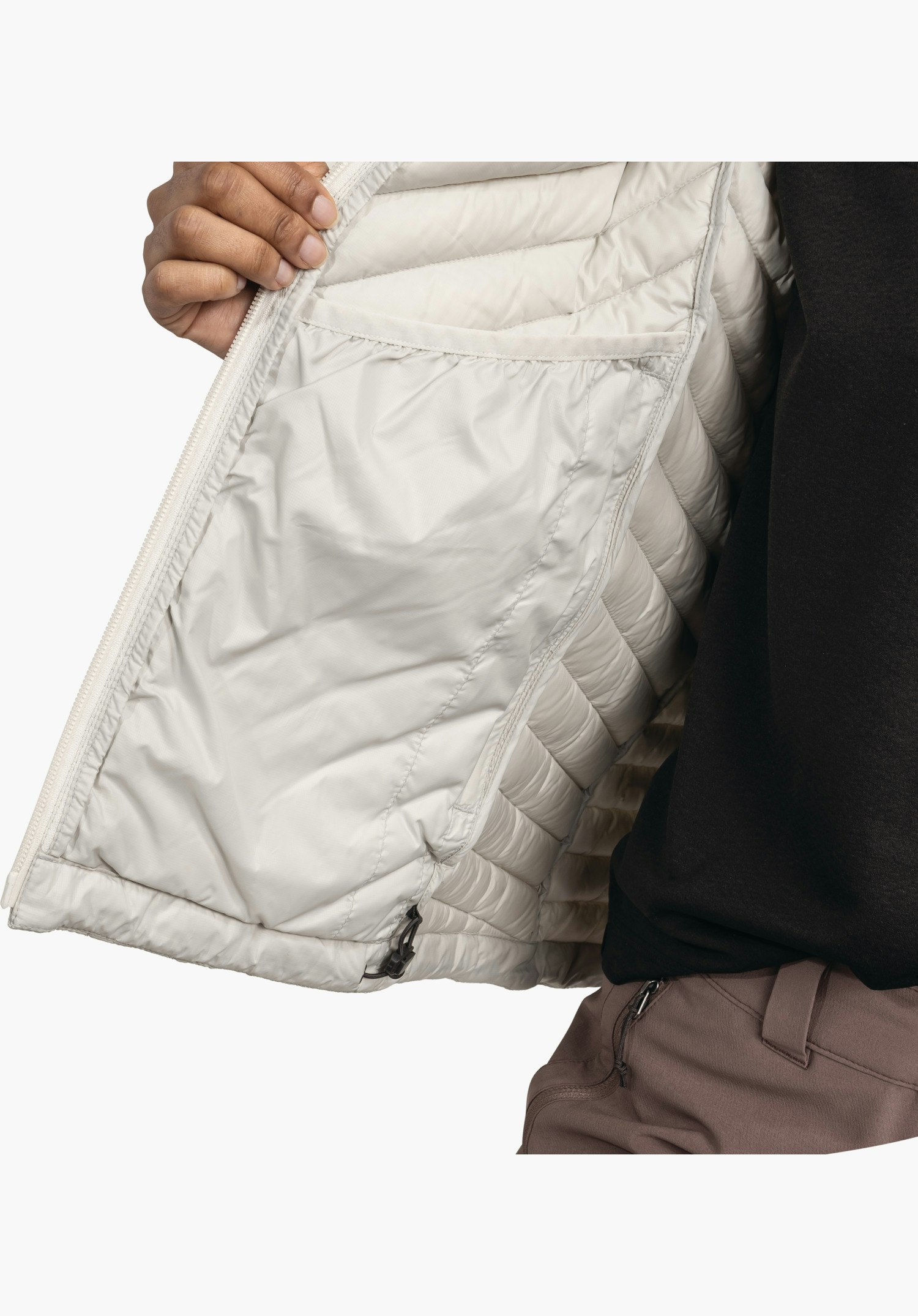 Down Jacket Style Cascata WMS zeigt das Innenfutter in Natur mit einer großen Innentasche und dem verstellbaren Saumkordelzug, Nahaufnahme vor weißem/neutralem Hintergrund.