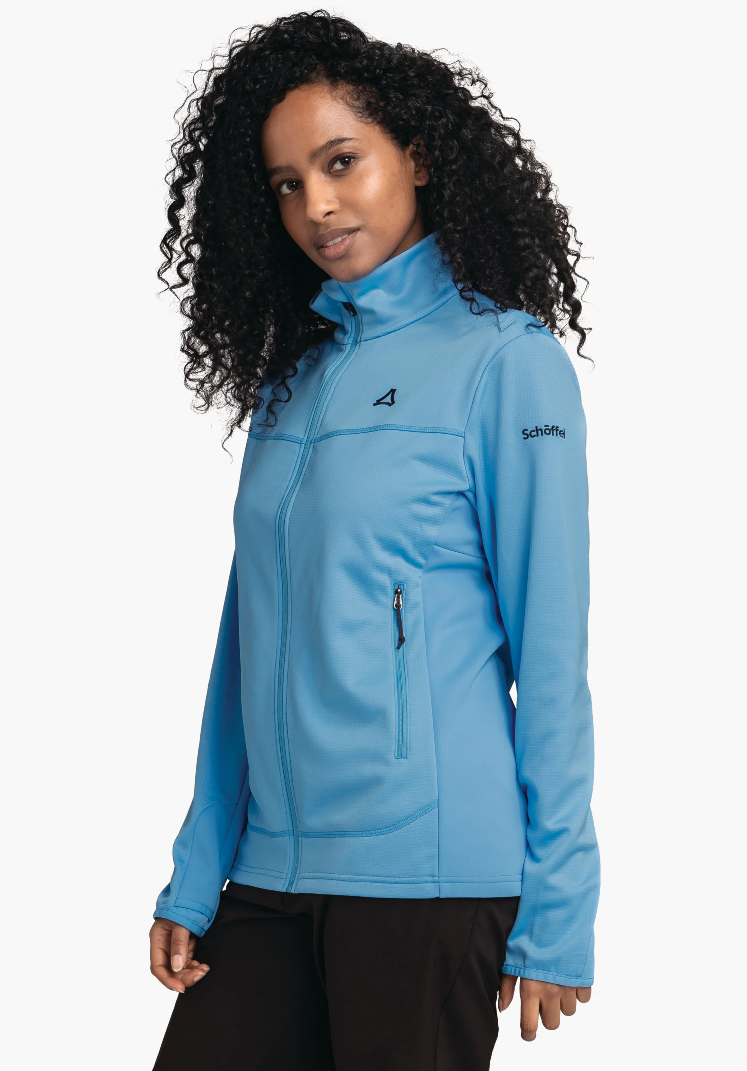 Fleece Jk Style Milagle WMS veste softshell bleu clair; personne la porte, debout de profil devant fond blanc; logo Schöffel sur la poitrine, inscription "Schöffel" sur la manche.