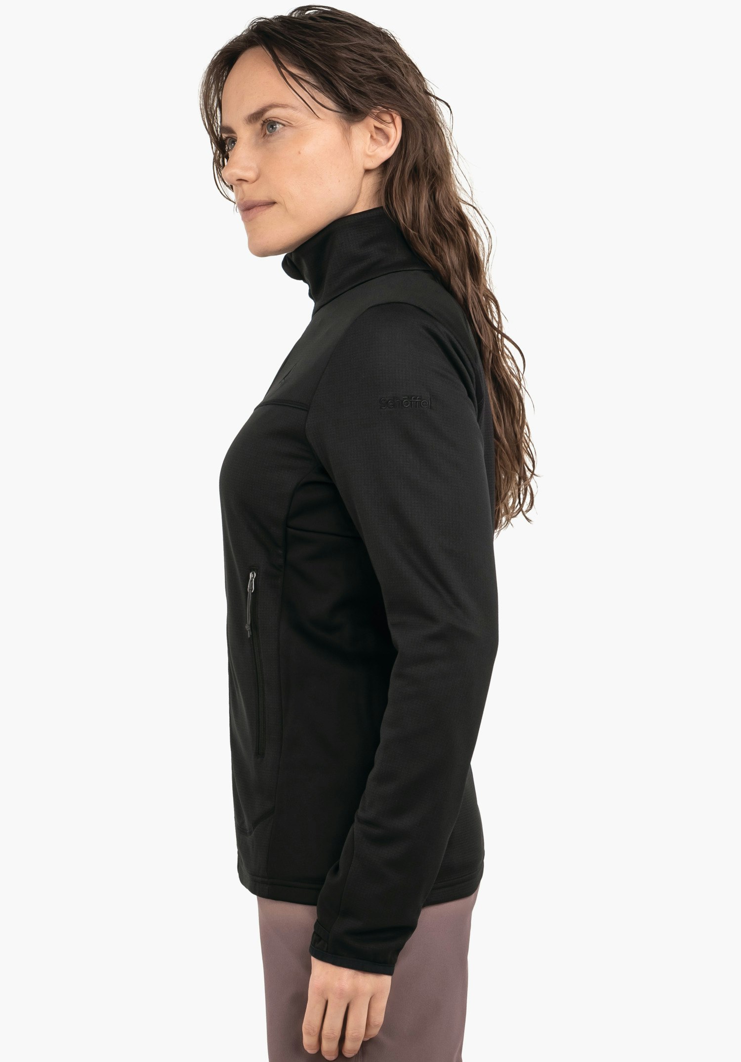 Fleece Jk Style Milagle WMS veste femme: femme portant une veste noire, debout de profil et regardant vers l’avant, devant fond blanc; texte sur la manche: "schöffel"; pantalon violet clair.