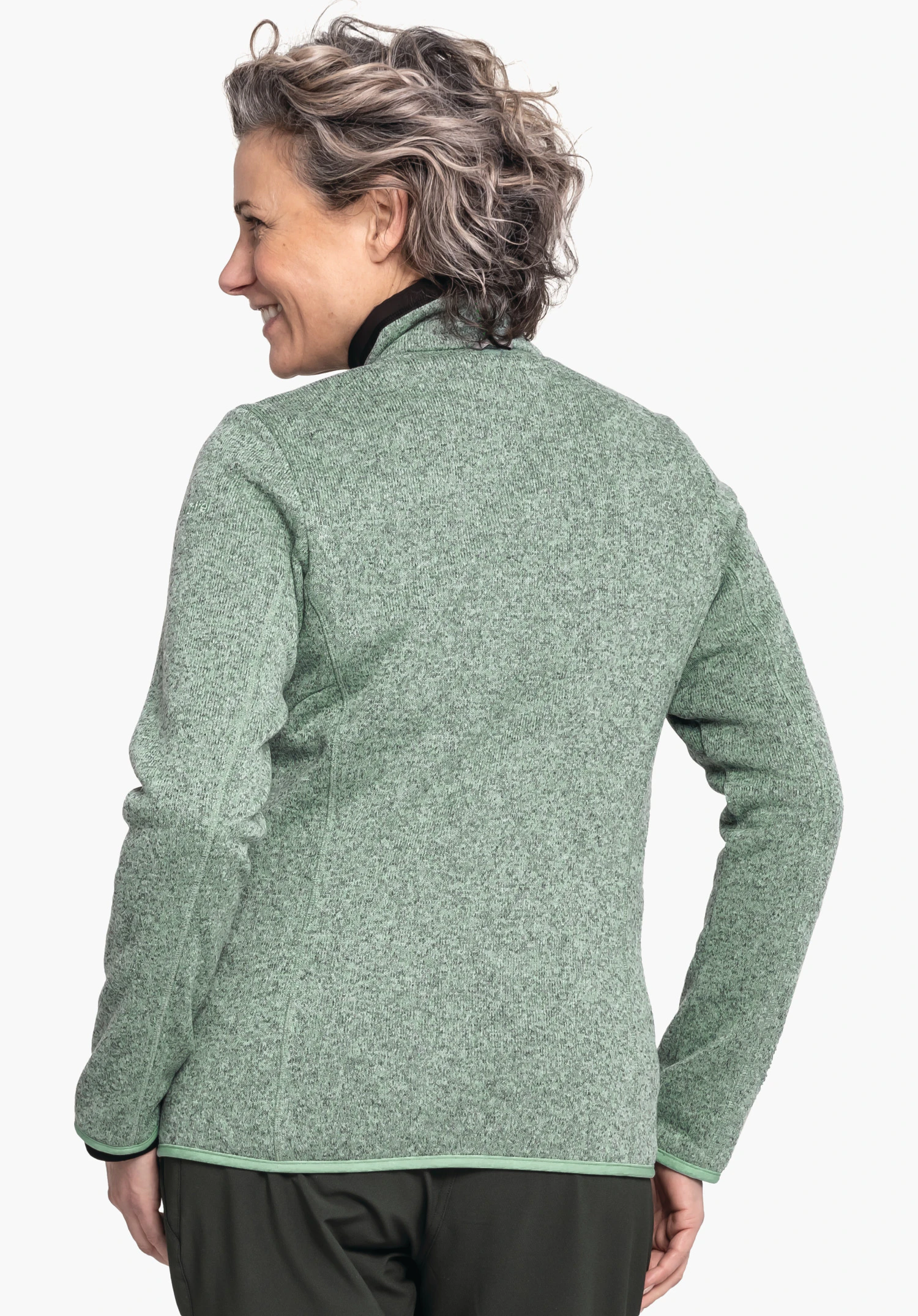 CIRC Fleece Jk Style Yew WMS veste polaire vert clair, portée par une femme souriante; elle regarde sur le côté, vue arrière devant un fond blanc.