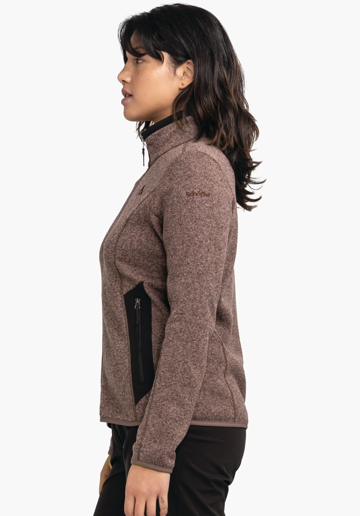 CIRC Fleece Jk Style Yew WMS veste portée de profil; modèle porte une veste polaire marron clair avec poche zippée noire, debout devant fond clair. Visible: logo Schöffel et texte "Schöffel".