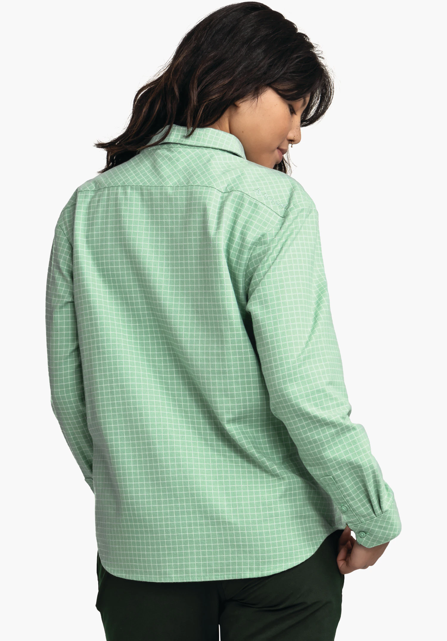 Blouse Style Boyoma WMS hellgrünes kariertes Hemd, von hinten getragen; Person neigt den Kopf seitlich; weißes Karomuster, Schöffel-Logo auf rechter Schulter; weißer Hintergrund, dunkelgrüne Hose sichtbar.