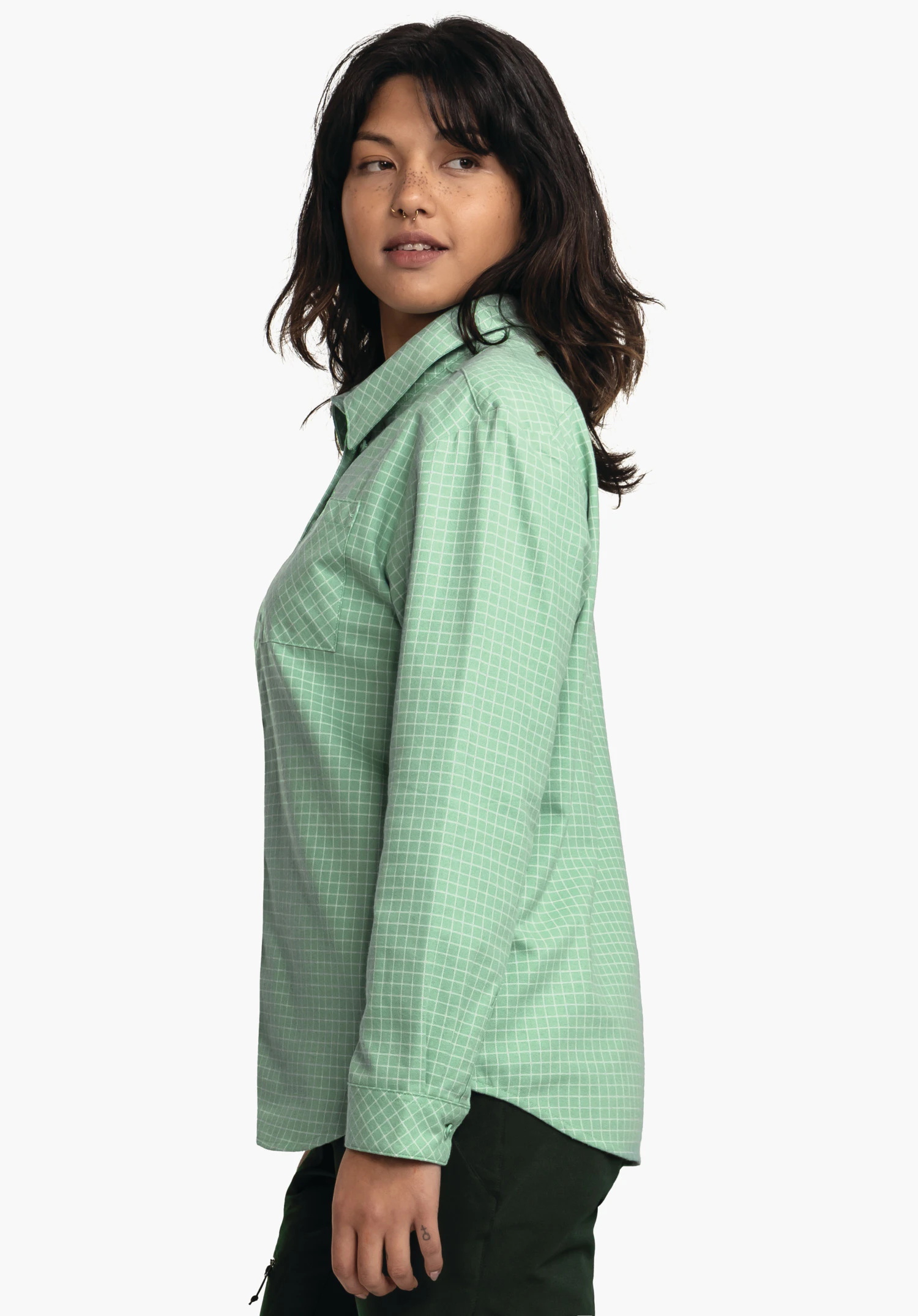Blouse Style Boyoma WMS hellgrünes kariertes Langarmhemd; getragen von stehender Person, die seitlich steht und nach rechts blickt; Kontext: weißer Hintergrund, dunkelgrüne Hose.