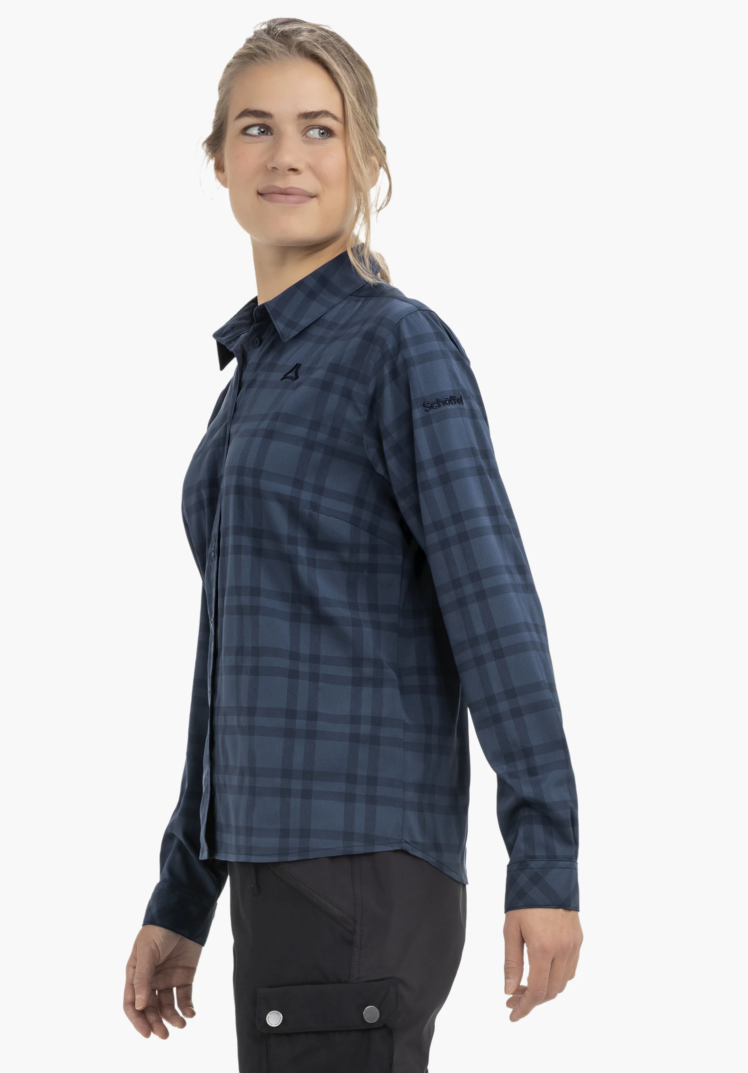 Blouse Style Yekuro WMS Dunkelblau karierte Hemdbluse mit Schöffel-Logo auf der Brust, getragen von Modell, schaut nach rechts; vor weißem Hintergrund. Text auf Ärmel: "Schöffel".