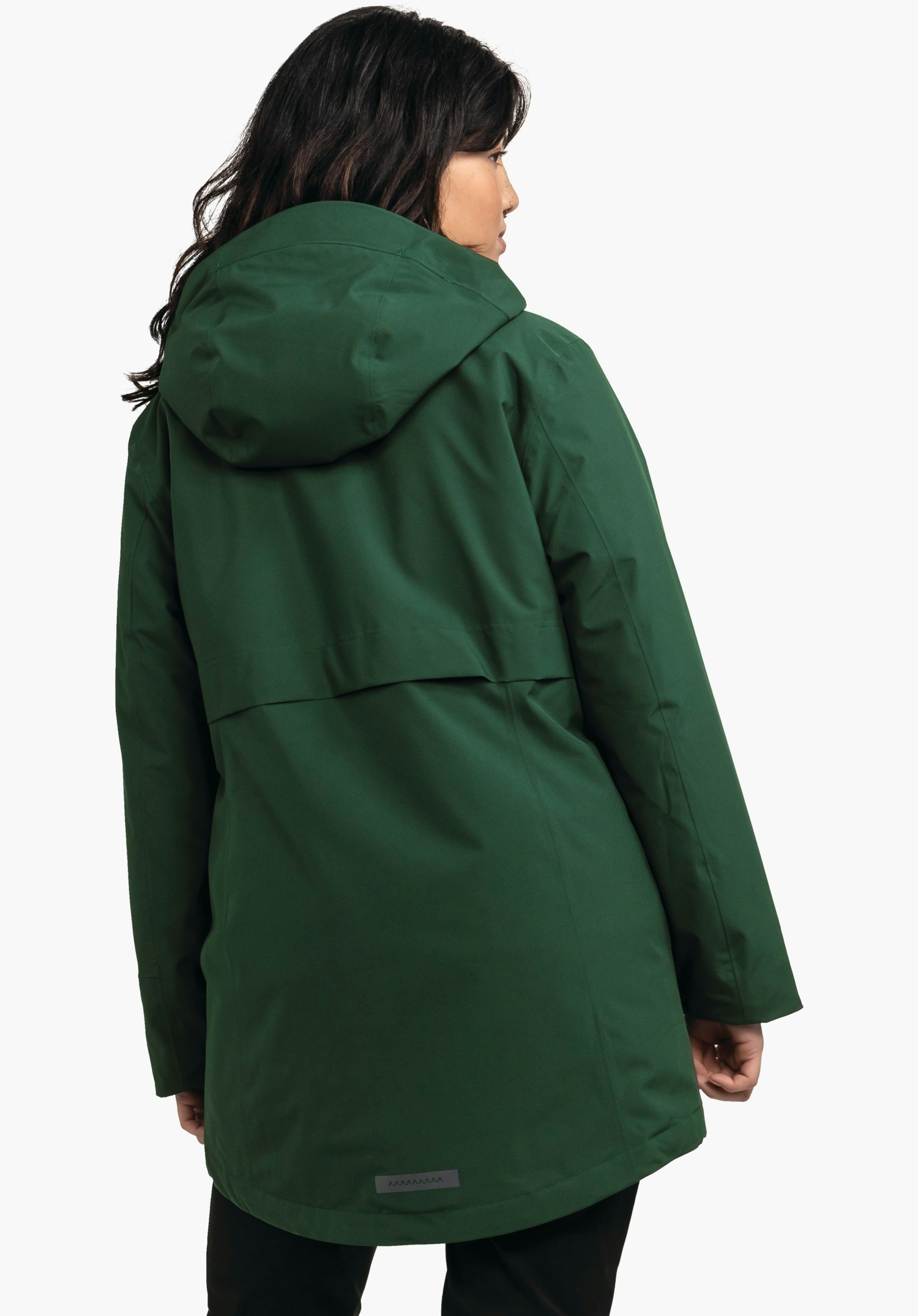 Ins Parka Style Malkay WMS parka vert foncé couvrant le dos, avec capuche; portée par une personne regardant légèrement sur le côté; fond blanc neutre.