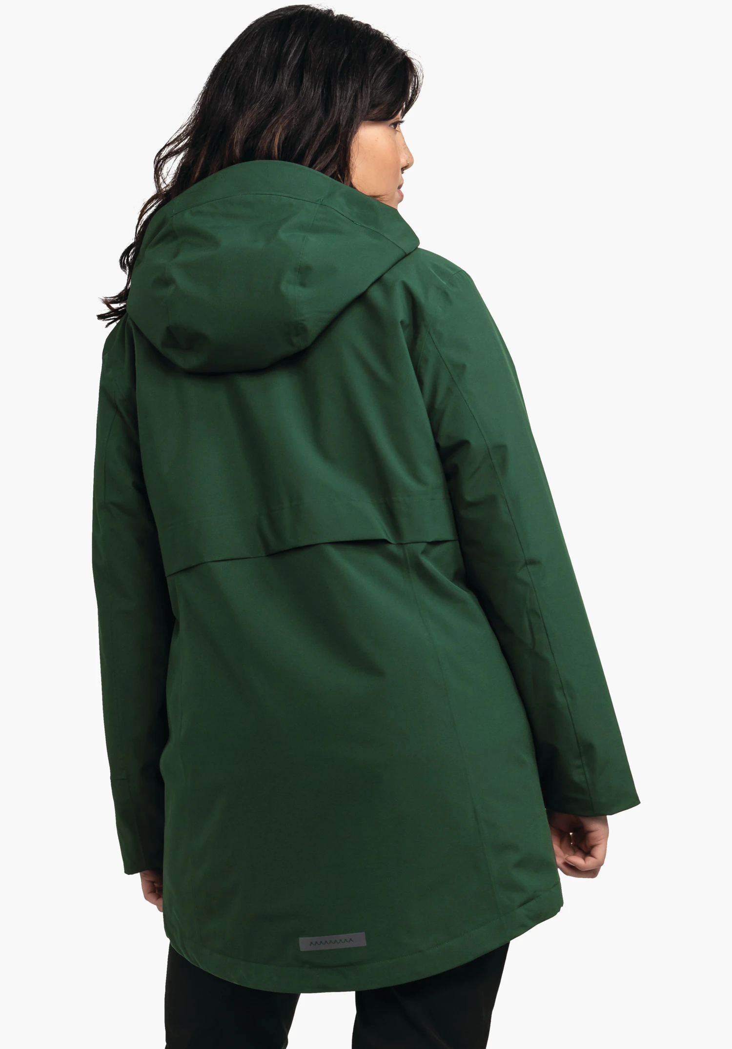 Ins Parka Style Malkay WMS donkergroene parka bedekt de rug en heeft een capuchon; gedragen door een persoon die licht opzij kijkt; neutrale witte achtergrond.
