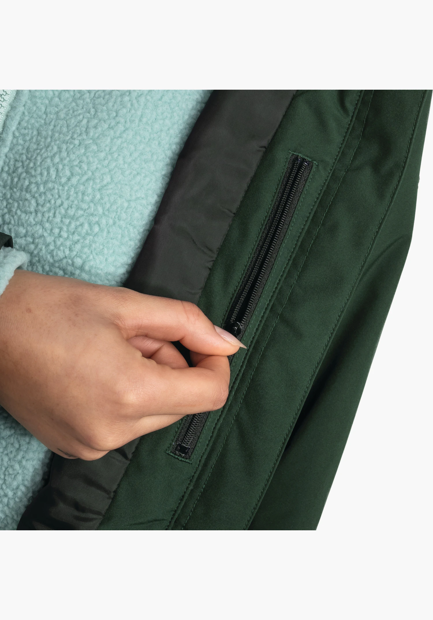 Ins Parka Style Malkay WMS toont de binnenkant met een praktische ritszak in de groene stof die door een hand wordt bediend, close-up voor een witte achtergrond.