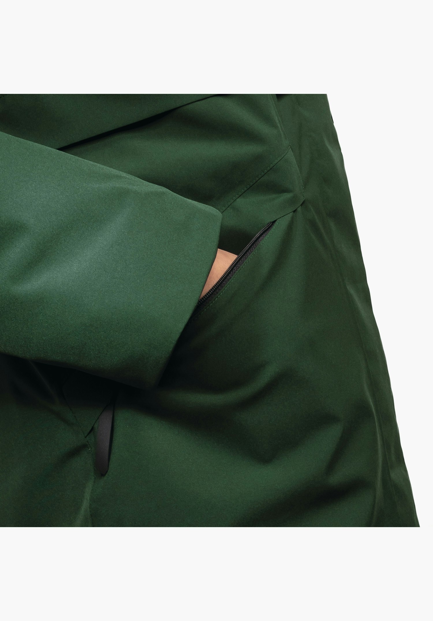 Ins Parka Style Malkay WMS, détail de la poche latérale zippée et du bas de manche en tissu vert, gros plan sur fond blanc/neutre.