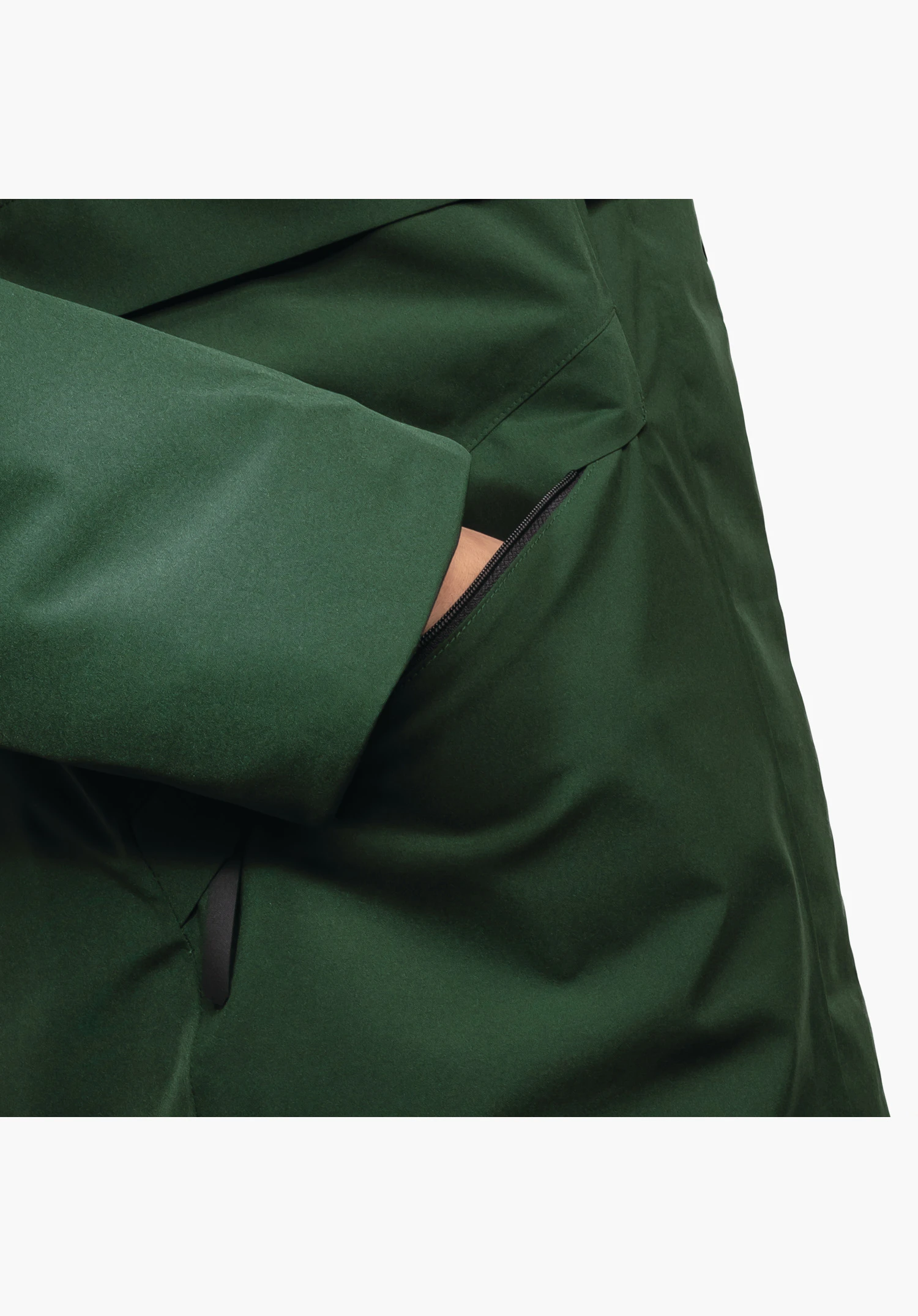 Ins Parka Style Malkay WMS, detail van de zijzak met rits en mouwboord in het groene materiaal, close-up tegen een witte/neutrale achtergrond.