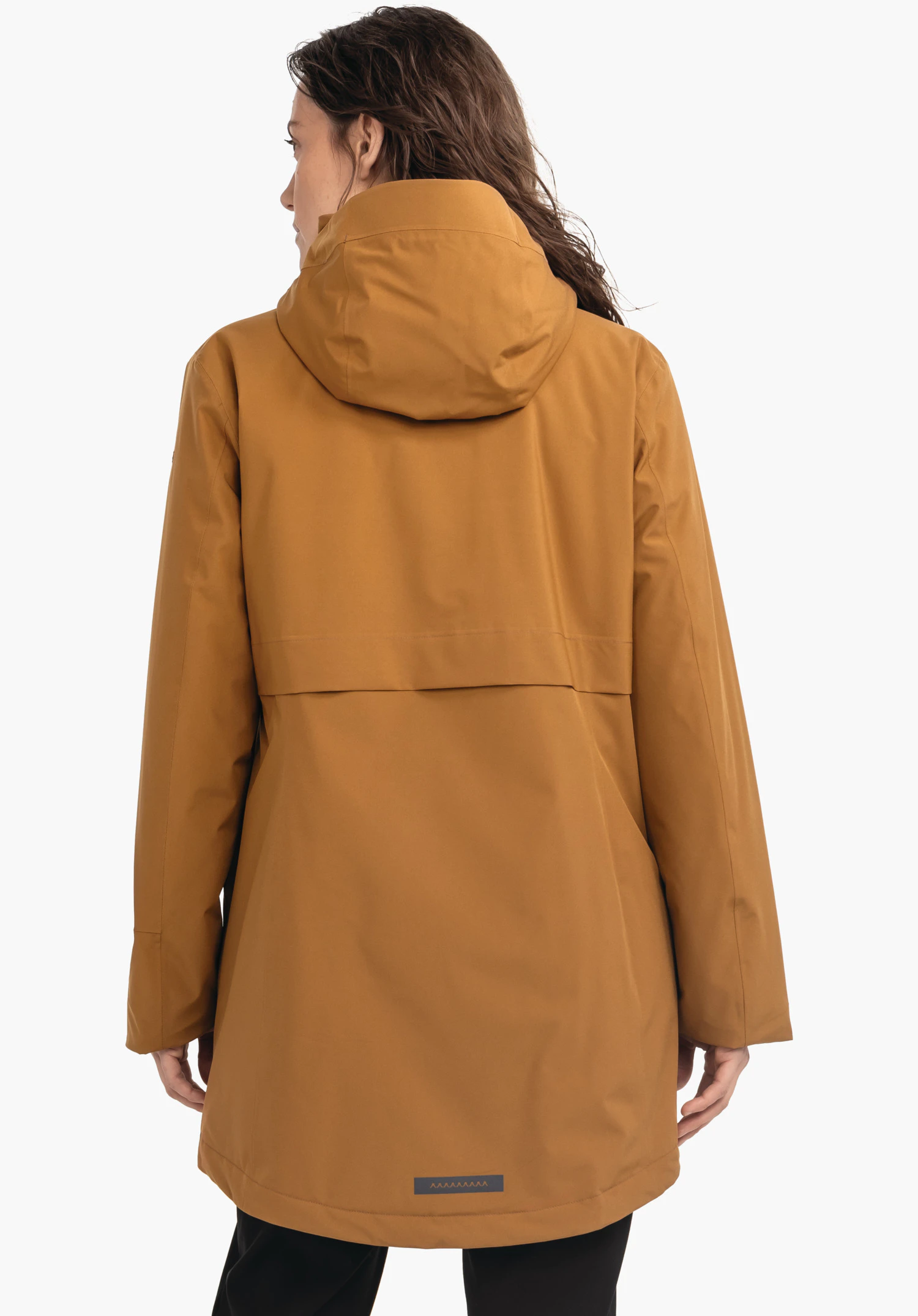 Ins Parka Style Malkay WMS donkergele parka, van achteren gedragen; capuchon op het hoofd, mouwen los naar beneden; persoon staat voor een effen lichte achtergrond.