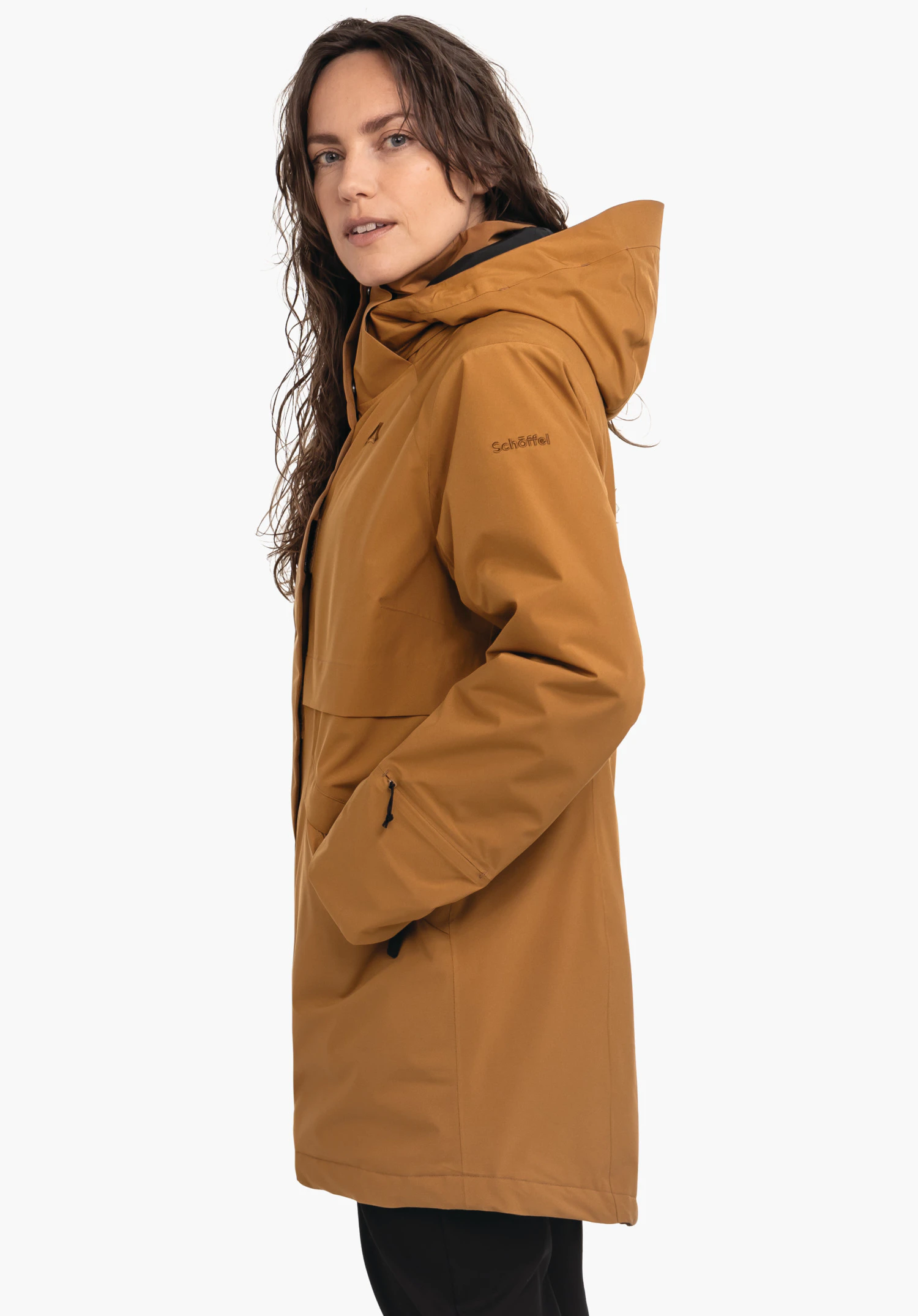 Ins Parka Style Malkay WMS donkeroranje parka, gedragen door een vrouw die over de schouder kijkt en handen in de zakken heeft; lichtwitte achtergrond. Tekst op de mouw: "Schöffel".