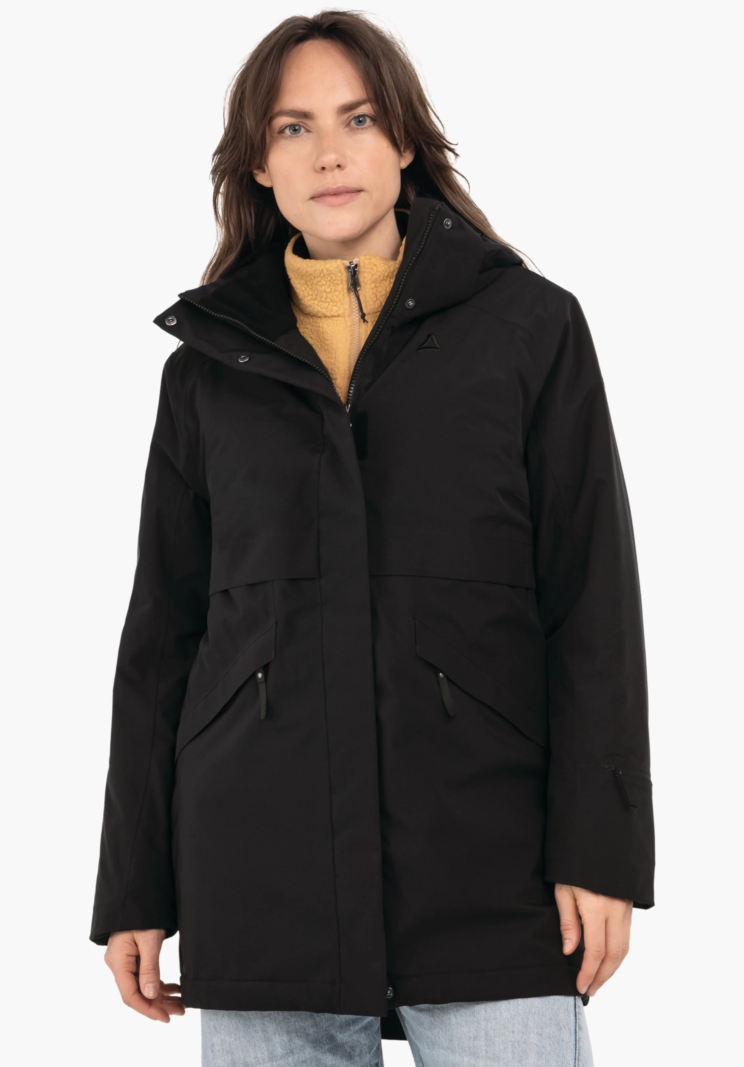 Ins Parka Style Malkay WMS woman wearing a black hooded jacket with Schöffel logo; light yellow fleece partially visible underneath; standing front-facing against a white background with arms relaxed, light blue jeans.