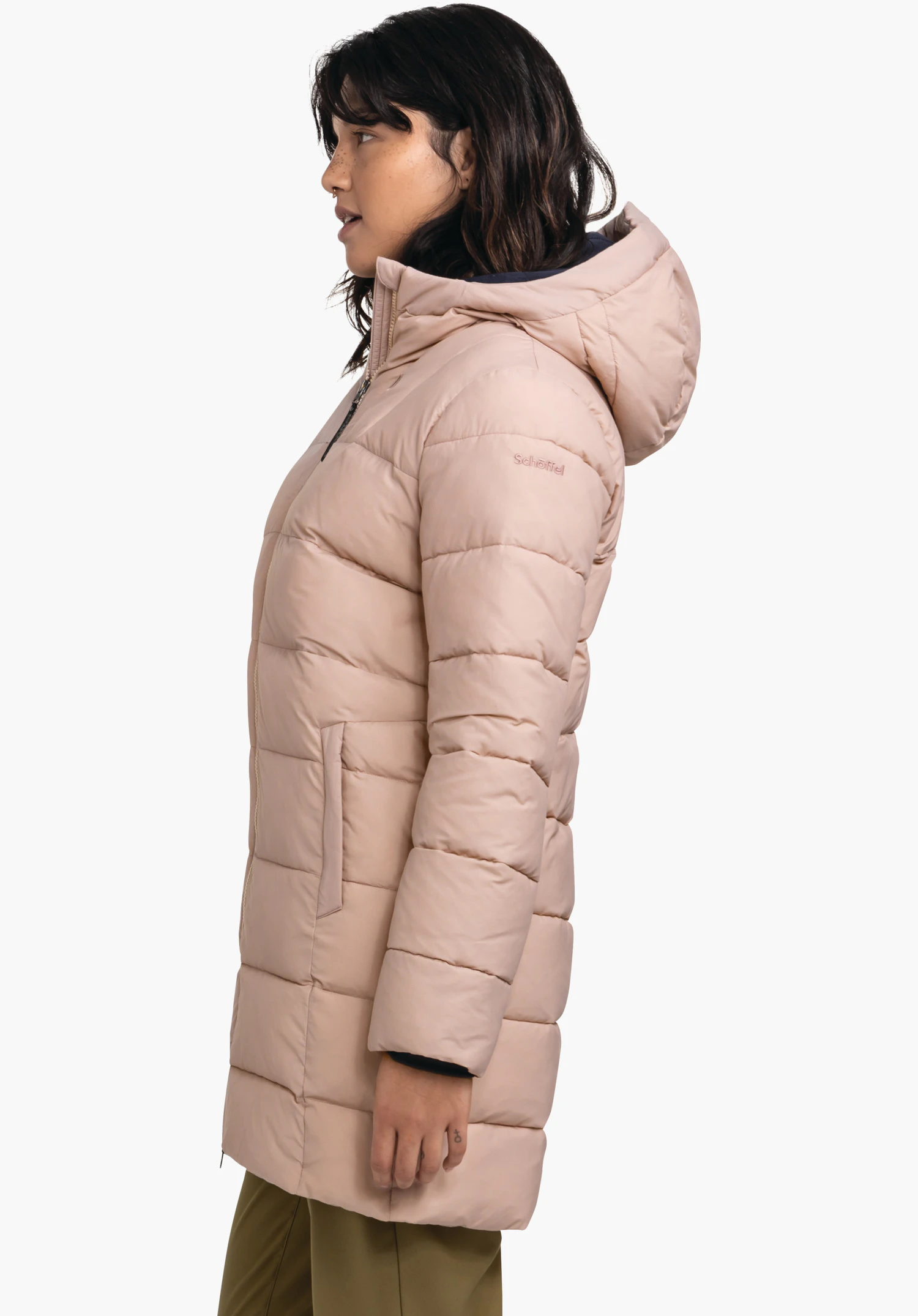 Ins Parka Style Boslix WMS light pink quilted jacket worn in side profile, high collar and hood with dark blue lining; person in front of a white background, green trousers. Text: "Schöffel".