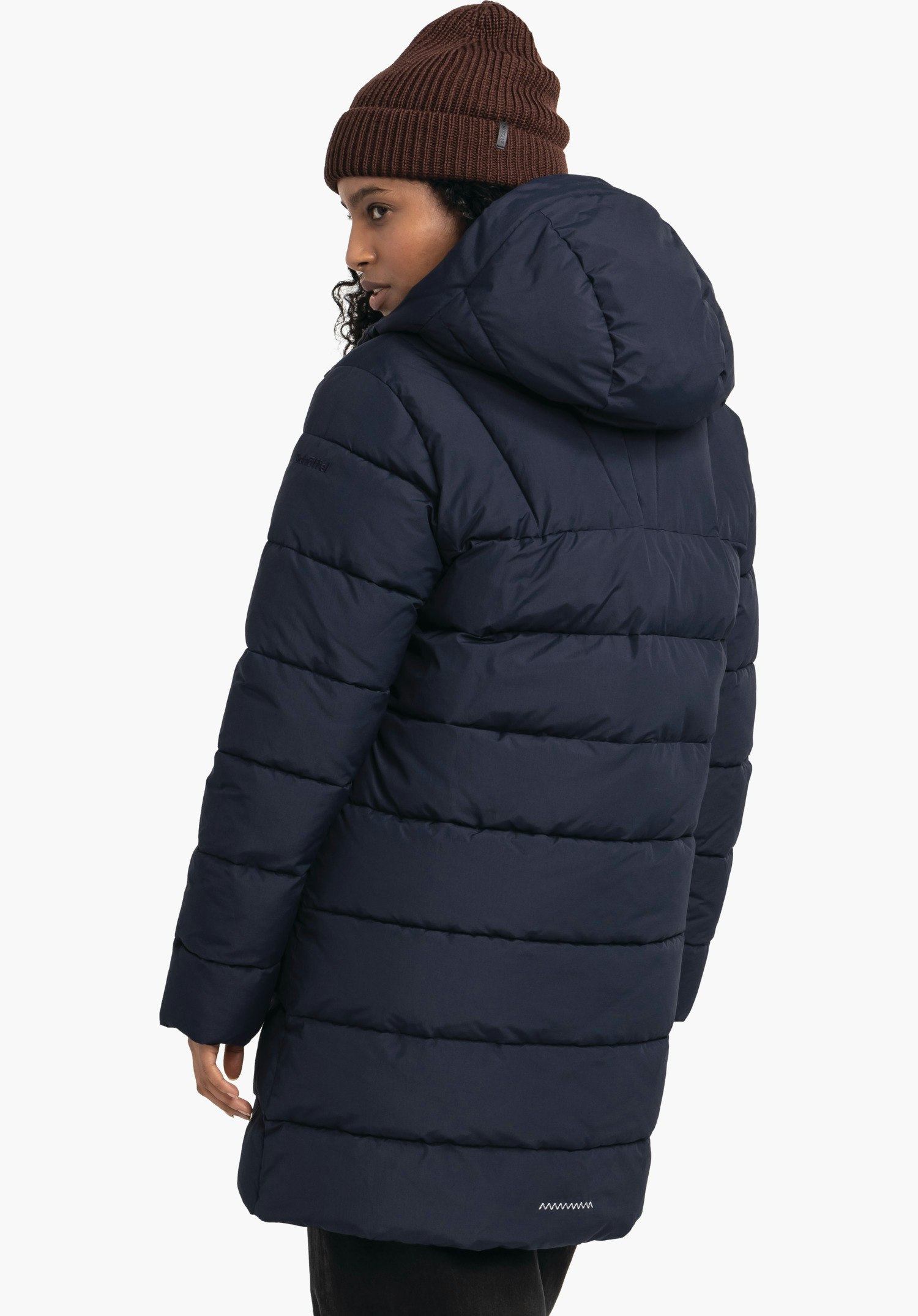 Ins Parka Style Boslix WMS dark blue knee-length quilted hooded coat worn by a person looking over the shoulder; light neutral background; brown knitted beanie visible.