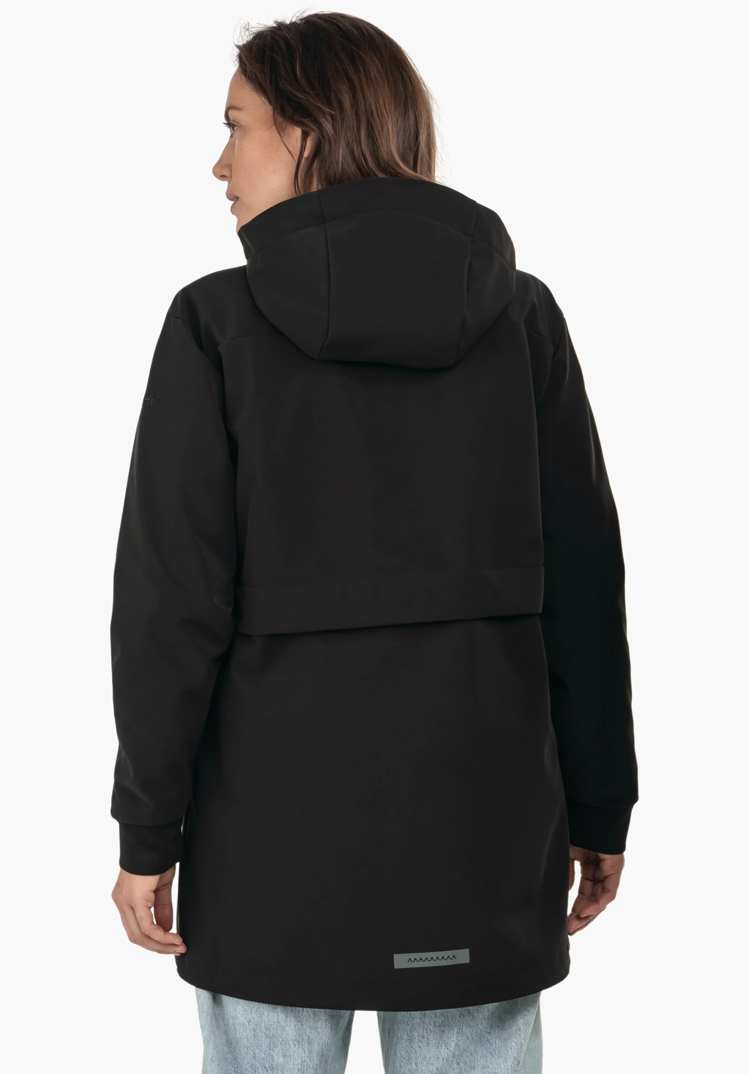 Softshell Jk Style Suavio WMS manteau softshell noir à capuche, porté par une personne debout dos à la caméra; mains détendues, jean bleu clair visible; fond blanc, patch réfléchissant en zigzag.