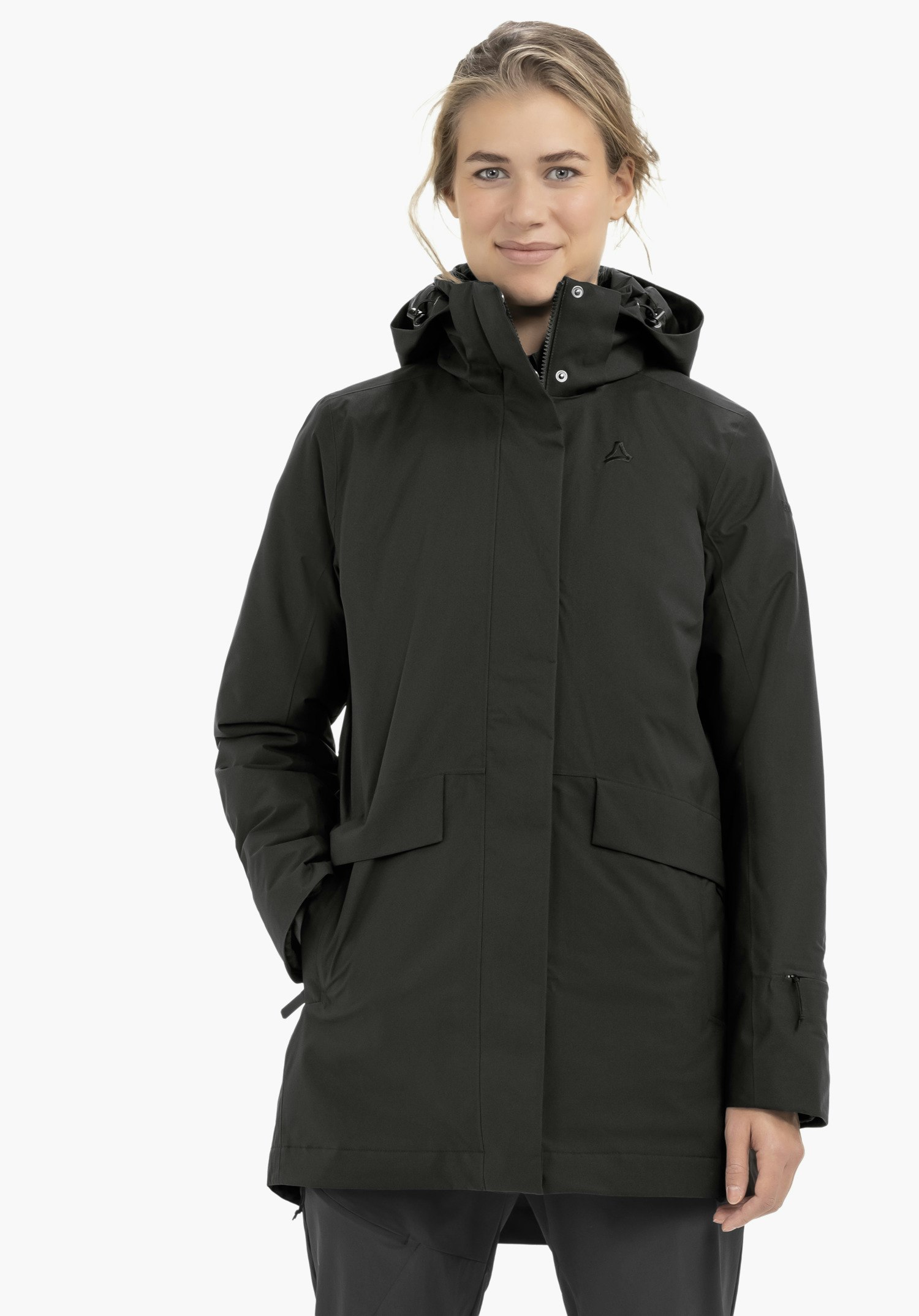 Blouse Style Lodos WMS vrouw draagt een wit corduroy overhemd, staat licht zijwaarts met hand in de zak en kijkt naar rechts; bruin haar, zwarte broek, neutrale lichte studioachtergrond. Schöffel-logo zichtbaar.
