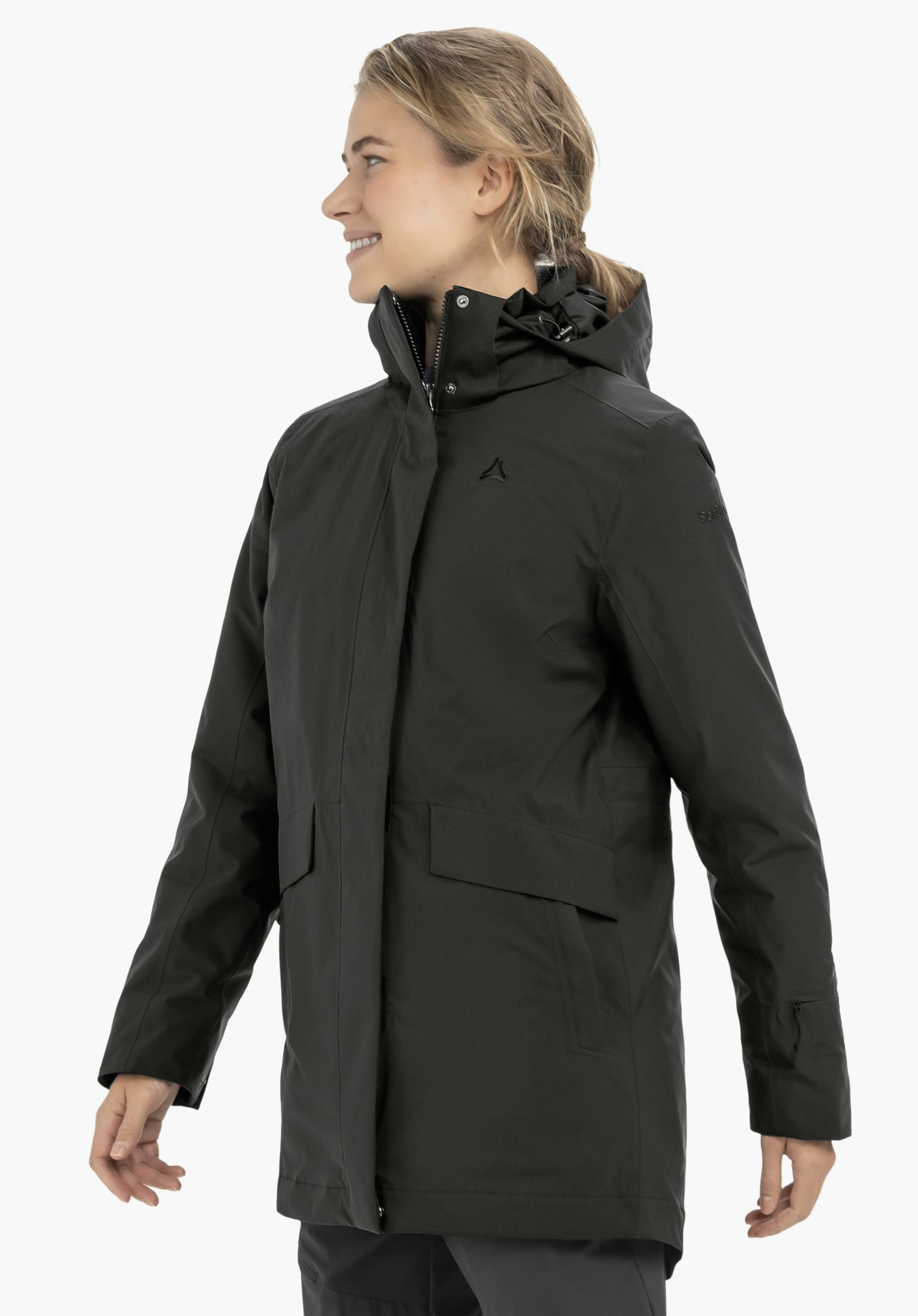 3in1 Parka Style Borkol WMS zwarte parka, gedragen door een glimlachend model in zijaanzicht; capuchon omhoog, handen ontspannen langs het lichaam; Schöffel-logo op de borst, lichtwitte achtergrond.