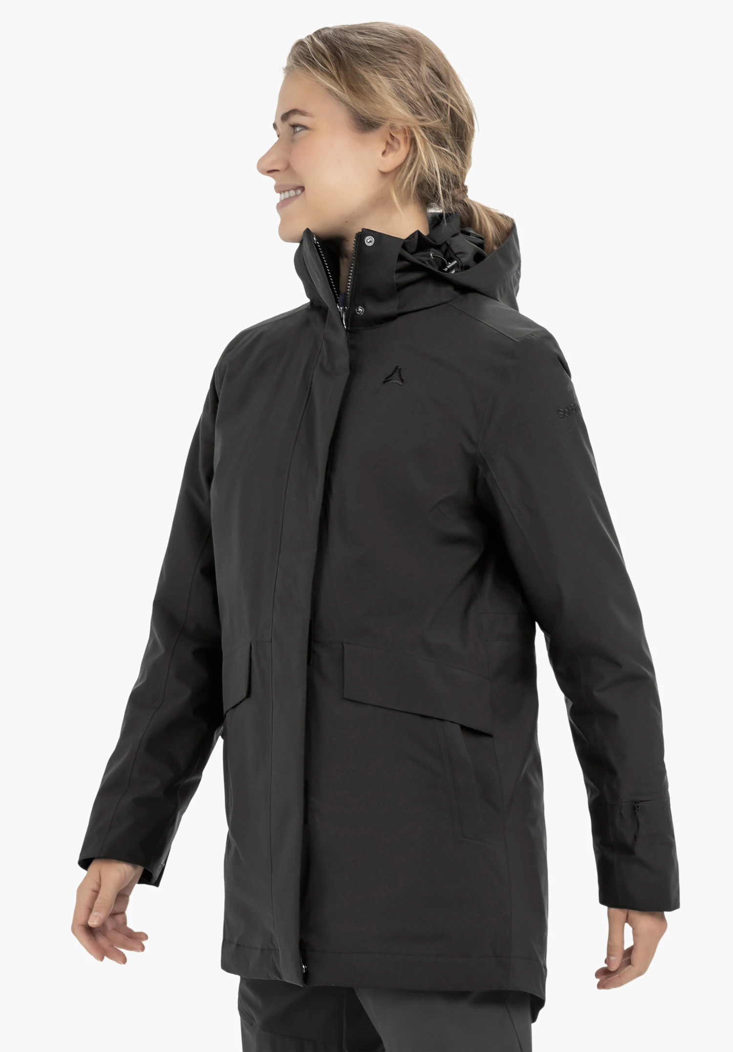 3in1 Parka Style Borkol WMS zwarte parka, gedragen door een glimlachend model in zijaanzicht; capuchon omhoog, handen ontspannen langs het lichaam; Schöffel-logo op de borst, lichtwitte achtergrond.