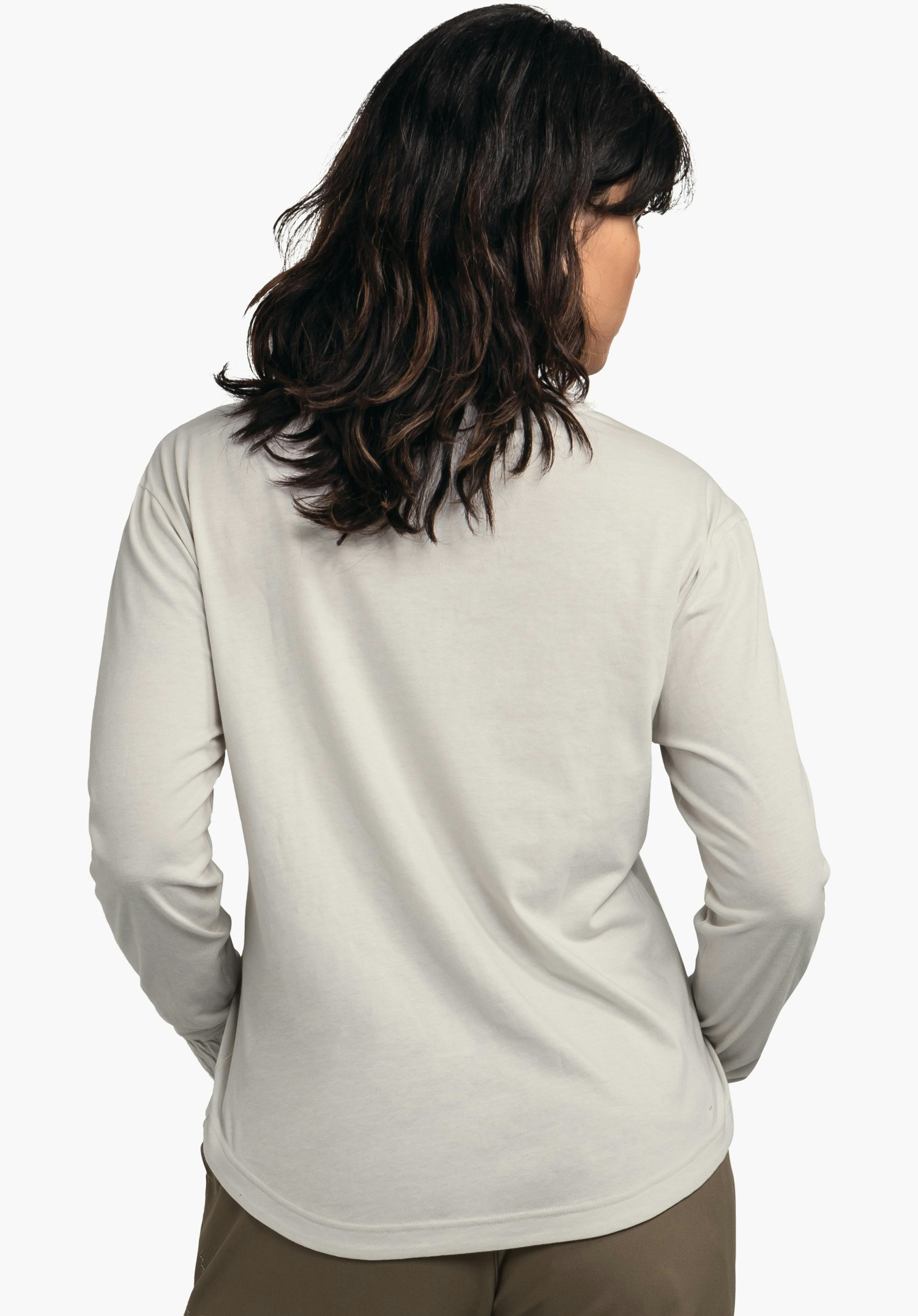 Longsleeve Style Collada WMS t-shirt manches longues; modèle debout dos à la caméra, mains sur les hanches, t-shirt blanc clair devant un fond blanc.