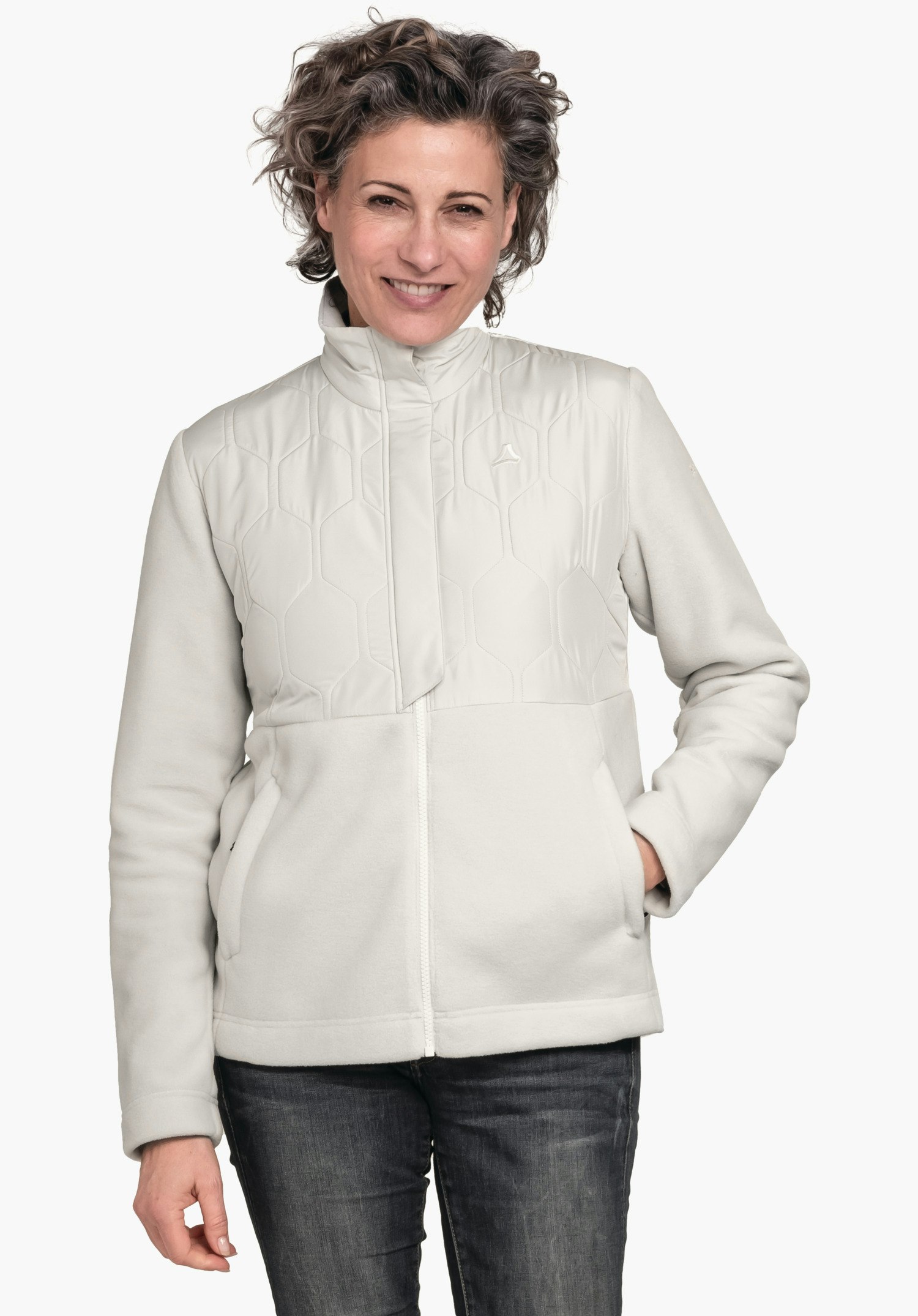 Fleece Jk Style Gregale WMS veste doublée blanc clair avec logo Schöffel; femme la portant, souriante, main droite dans la poche, pose debout devant un fond clair uni, jean bleu foncé.
