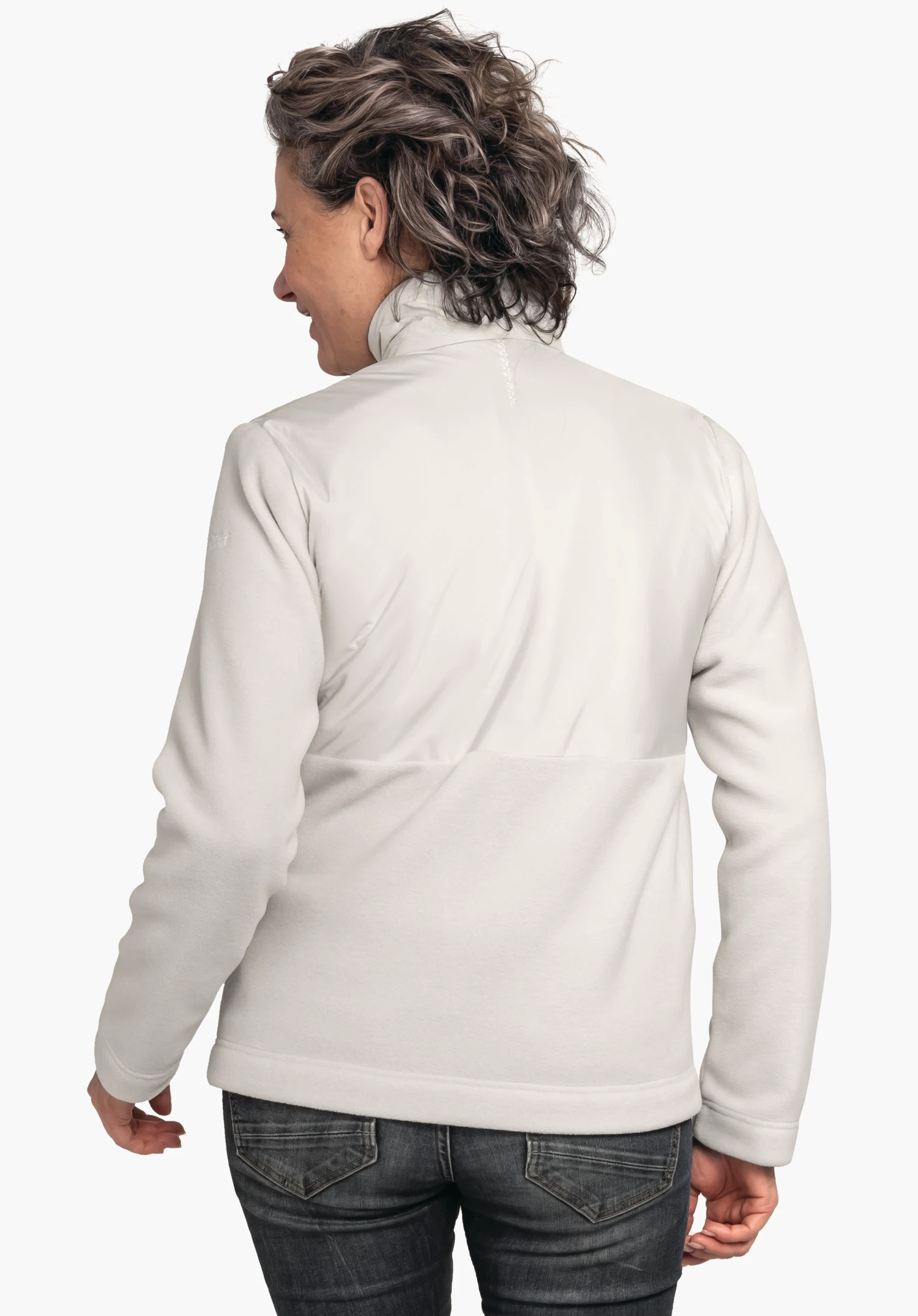 Fleece Jk Style Gregale WMS witte jas, gedragen door een persoon met de rug naar de camera en hoofd licht opzij gedraaid; donkergrijs haar, draagt donkergrijze jeans, lichte neutrale achtergrond.