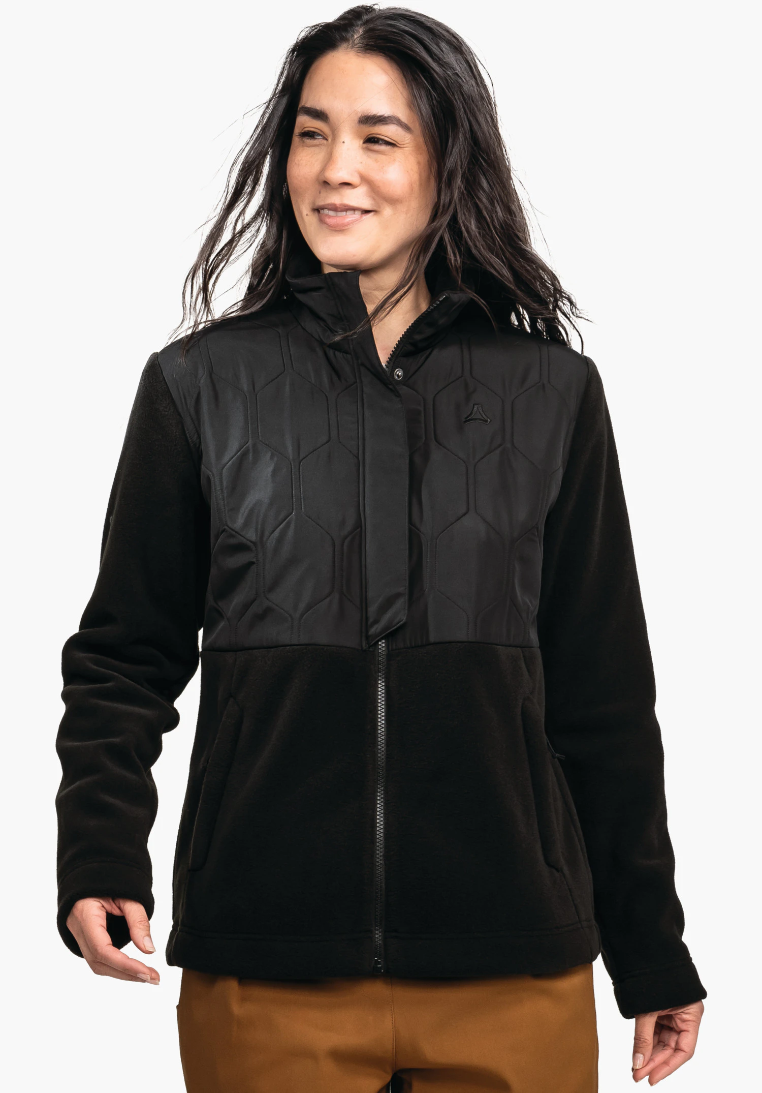 Fleece Jk Style Gregale WMS black jacket with quilted chest panel and Schöffel logo on the left chest; worn by a smiling model looking sideways; neutral background, dark orange trousers.