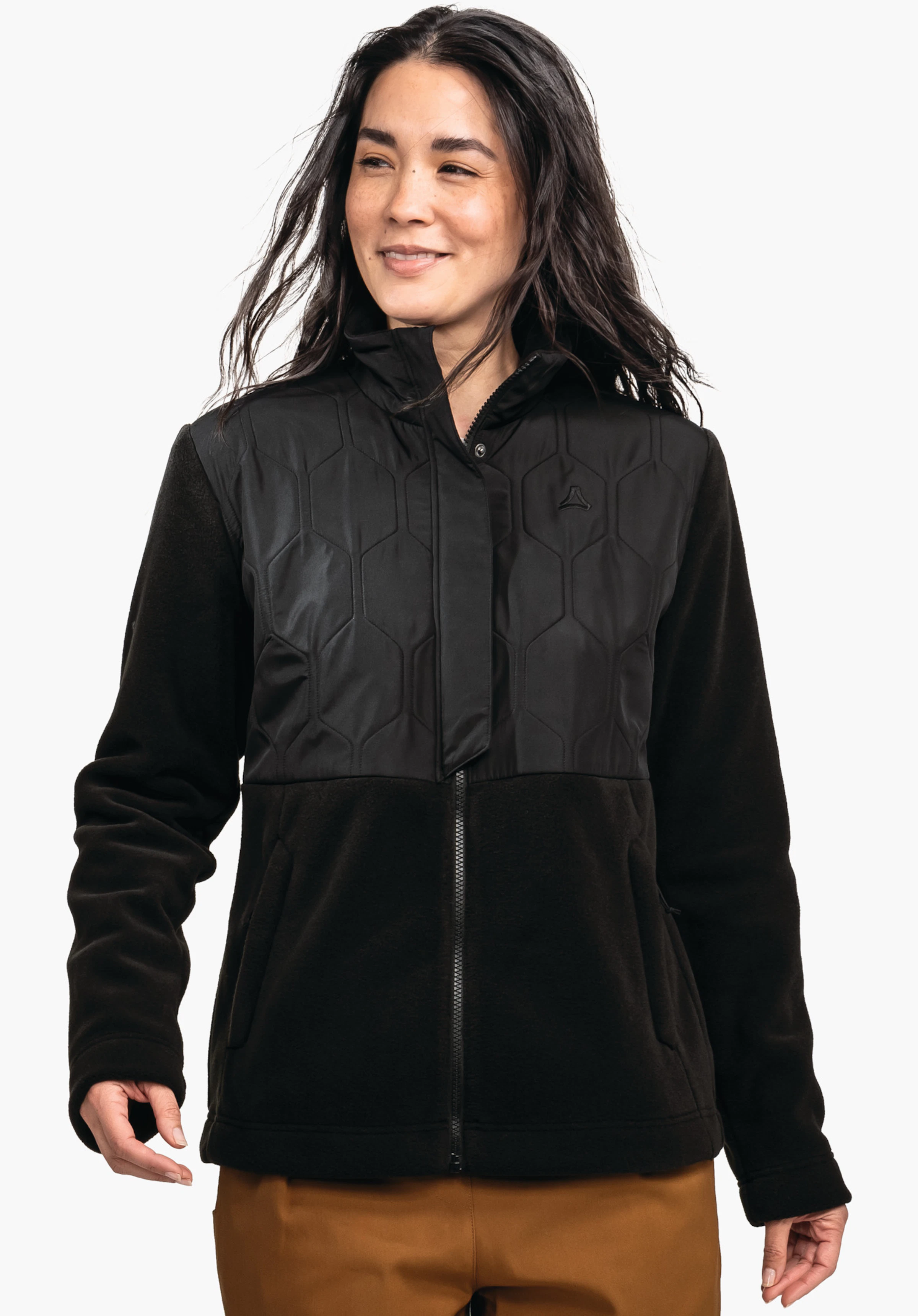 Fleece Jk Style Kalmor WMS lichtroze fleecejack, gedragen door een vrouw die zijwaarts kijkt; ritssluiting gesloten, rechterhand in de zak, Schöffel-logo op de borst, witte achtergrond.