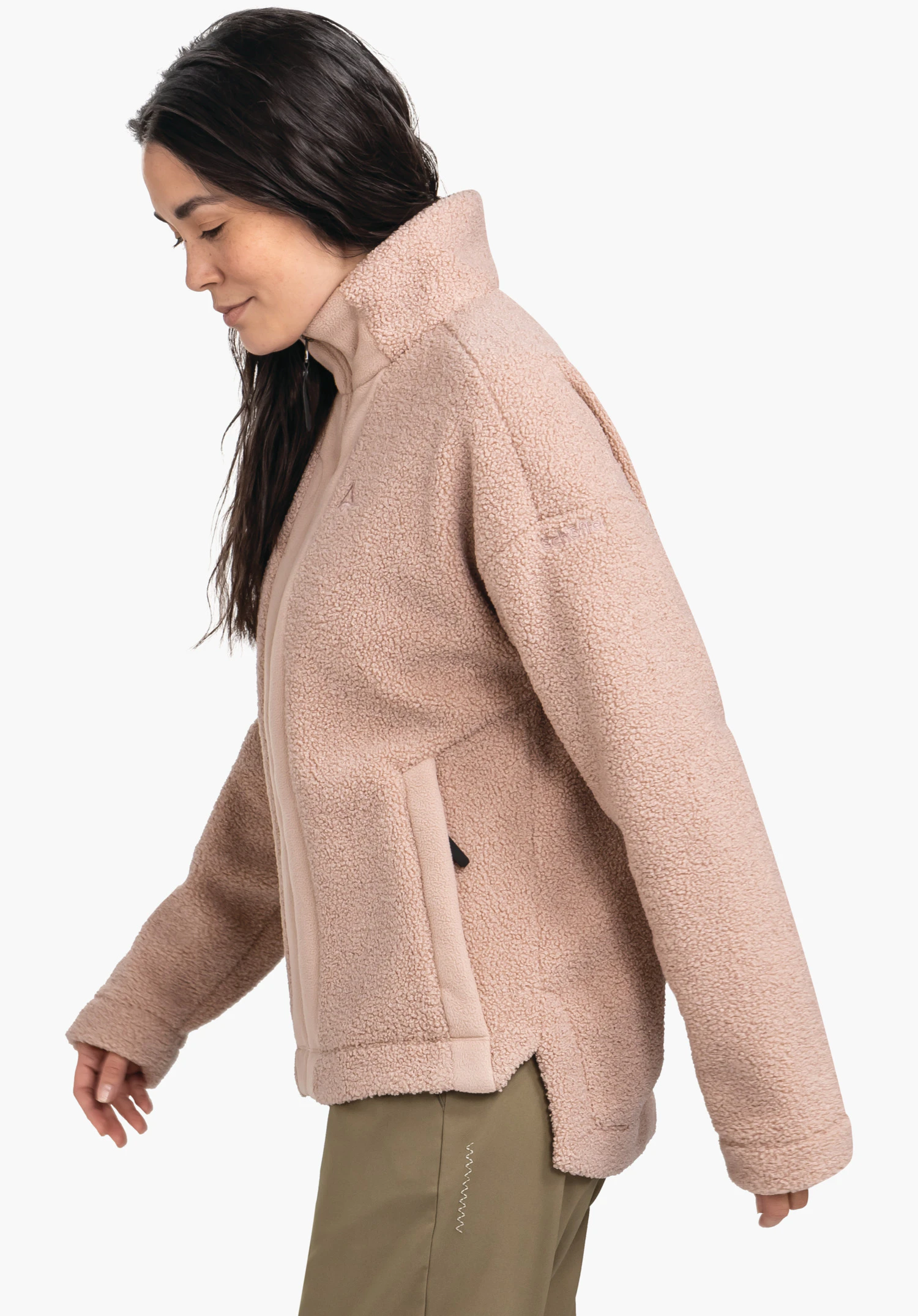 Fleece Jk Style Kalmor WMS hellrosa Fleecejacke, seitlich von einer Frau getragen; hoher Kragen, Reißverschluss und seitliche Taschen, Schöffel-Logo auf der Brust; neutraler weißer Hintergrund, dunkelgrüne Hose.